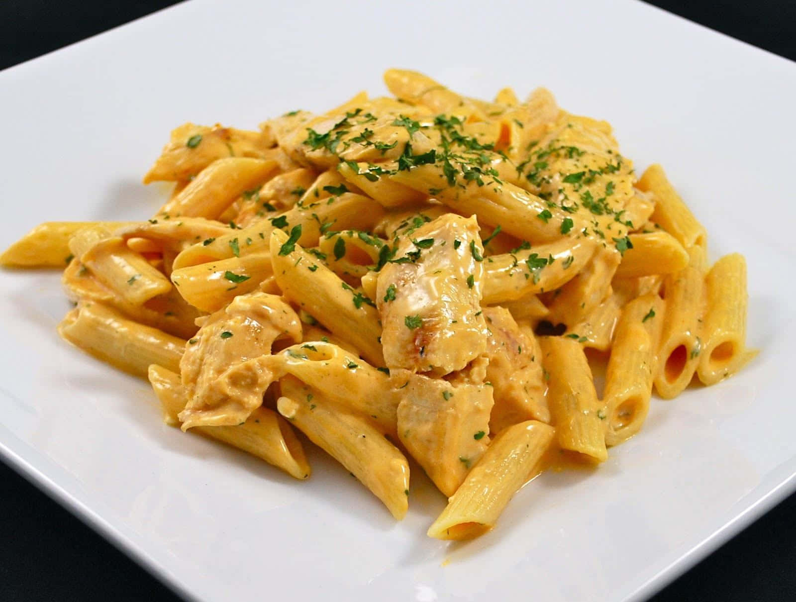 Pasta 桌布 壁紙 — 奶油雞肉長通粉配新鮮歐芹裝飾，盛載於白色盤子上。