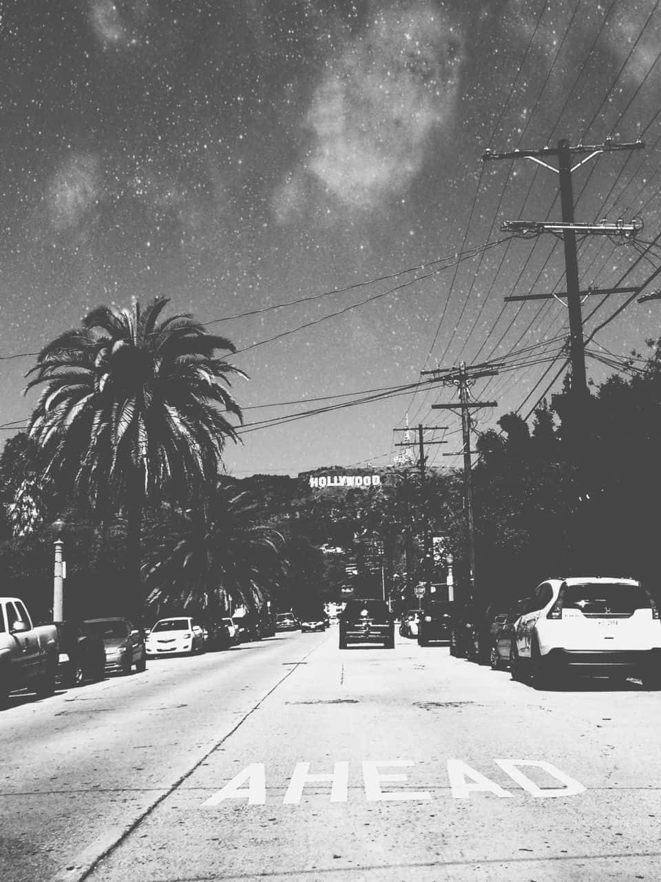 Aesthetic Black And White 桌布 壁紙 — 好萊塢的黑白街景，棕櫚樹、汽車和標誌性的標誌在星空下。