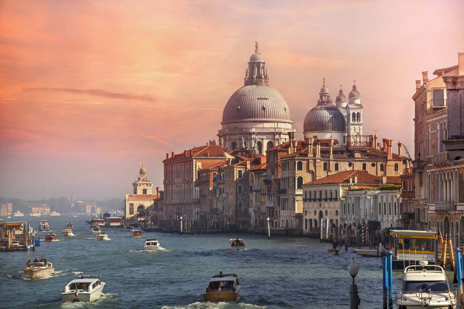 Italian 桌布 壁紙 — 威尼斯日落時分，圓頂大教堂和運河船隻在溫暖的粉紅色和橙色天空下。