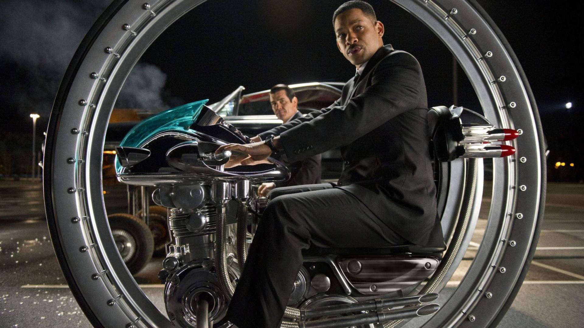 Men In Black 桌布 壁紙 — 威爾史密斯在夜燈下騎著一輛鍍鉻機車，被一個巨大的金屬環框住。