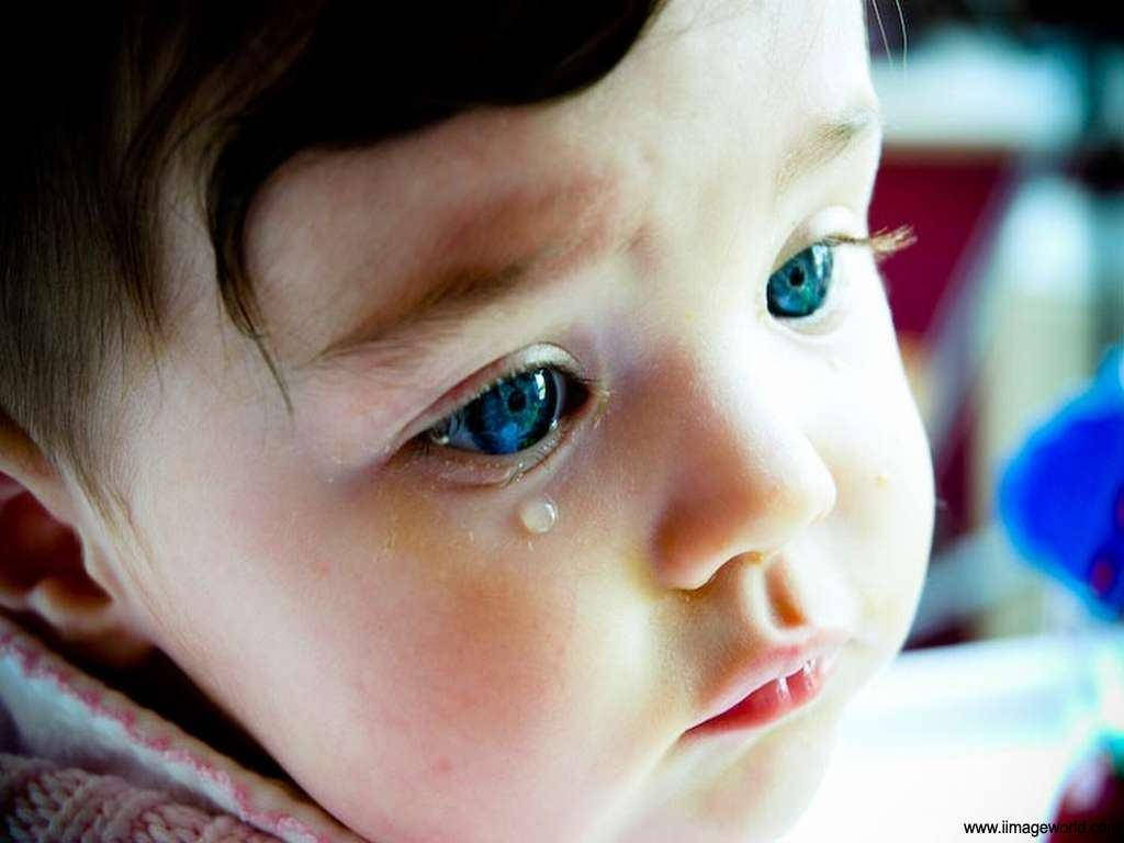 crying sad boy 桌布 壁紙 — 嬰兒哭泣臉部的特寫，擁有明亮的藍色眼睛和一顆淚珠沿著臉頰滾落。