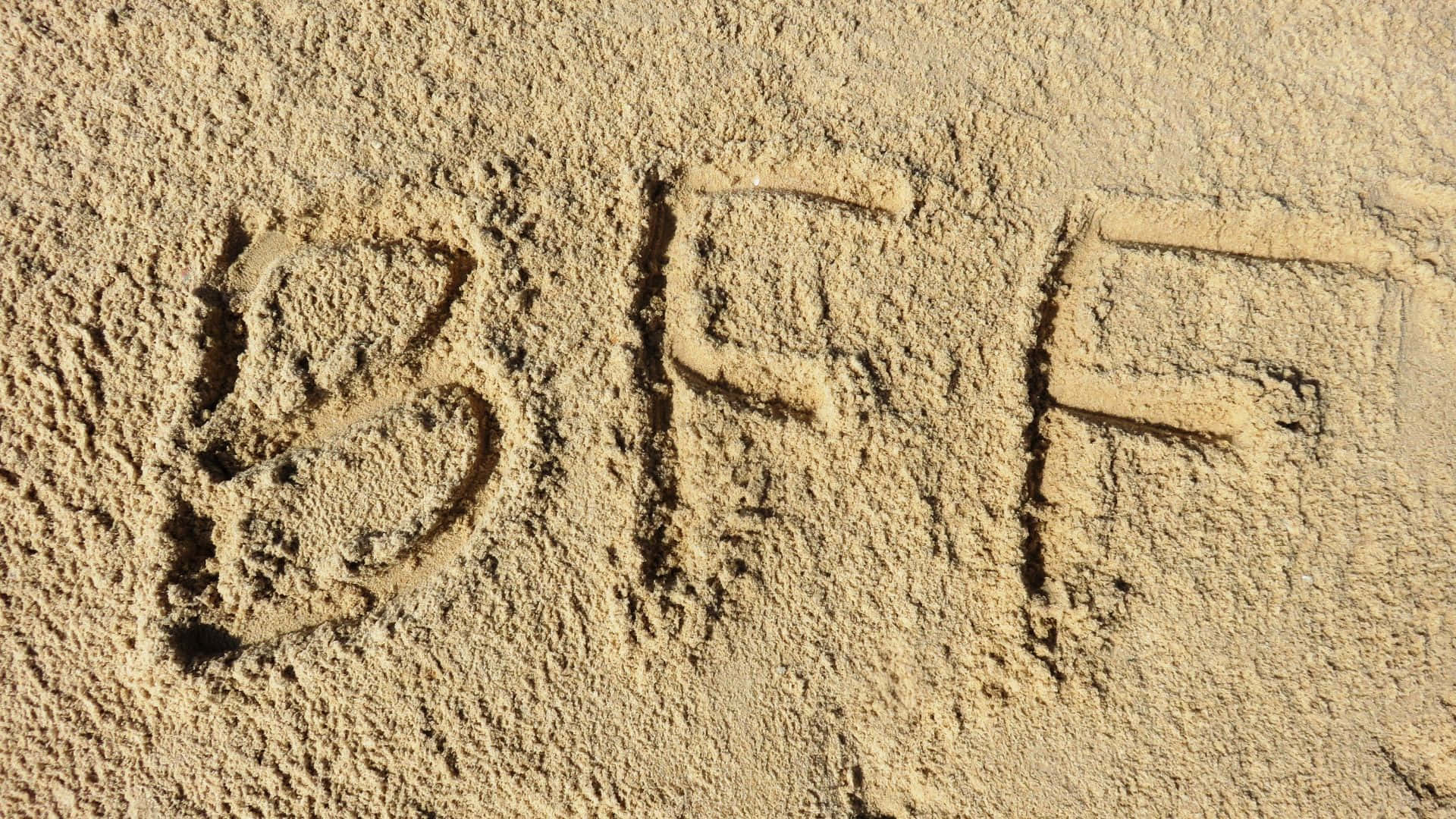 摯友 桌布 壁紙 — 字母BFF刻在質感沙地上，在明亮的日光下。