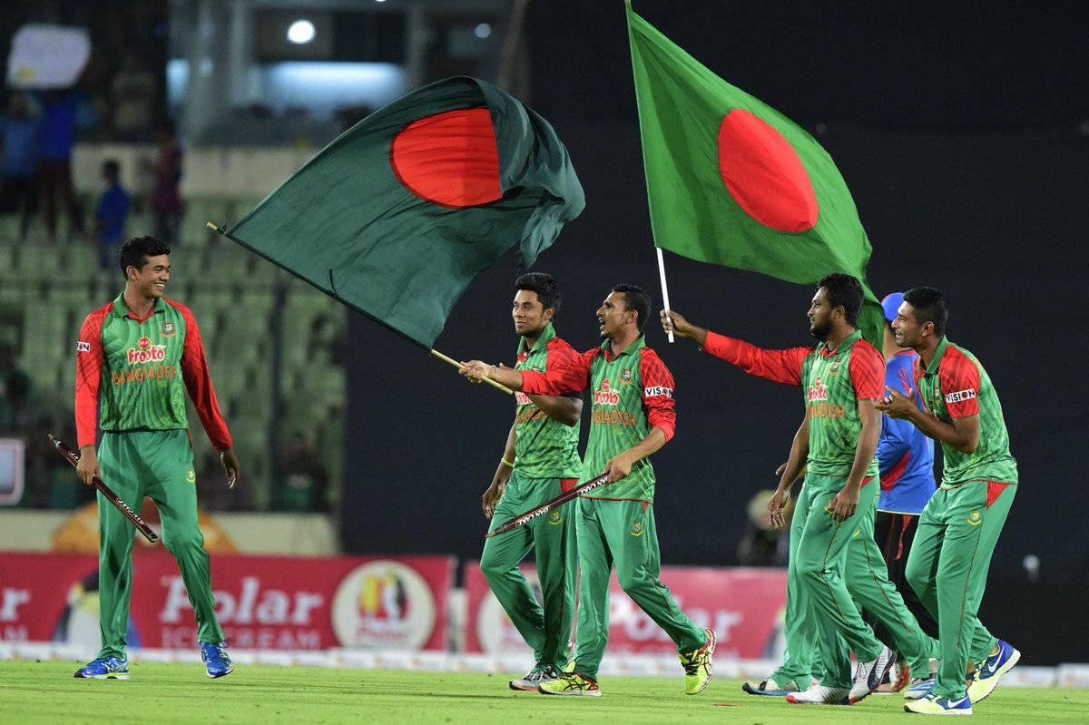 Bangladesh Cricket 桌布 壁紙 — 孟加拉國板球隊球員在夜燈下的體育場場地上揮舞國旗慶祝勝利。