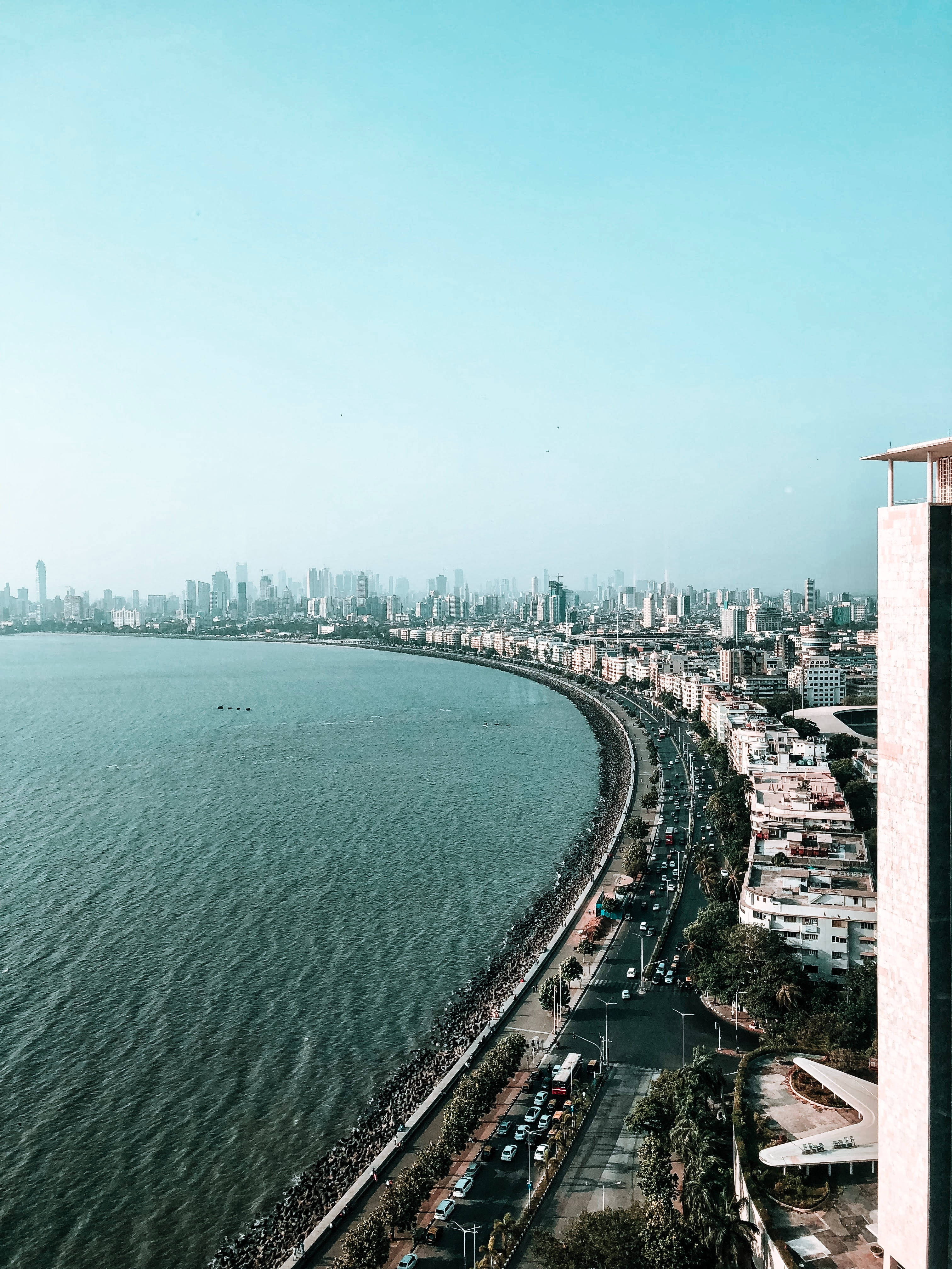 Mumbai 桌布 壁紙 — 孟買海岸線的鳥瞰圖，繁忙的道路交通和密集的城市天際線在清澈的藍天下。