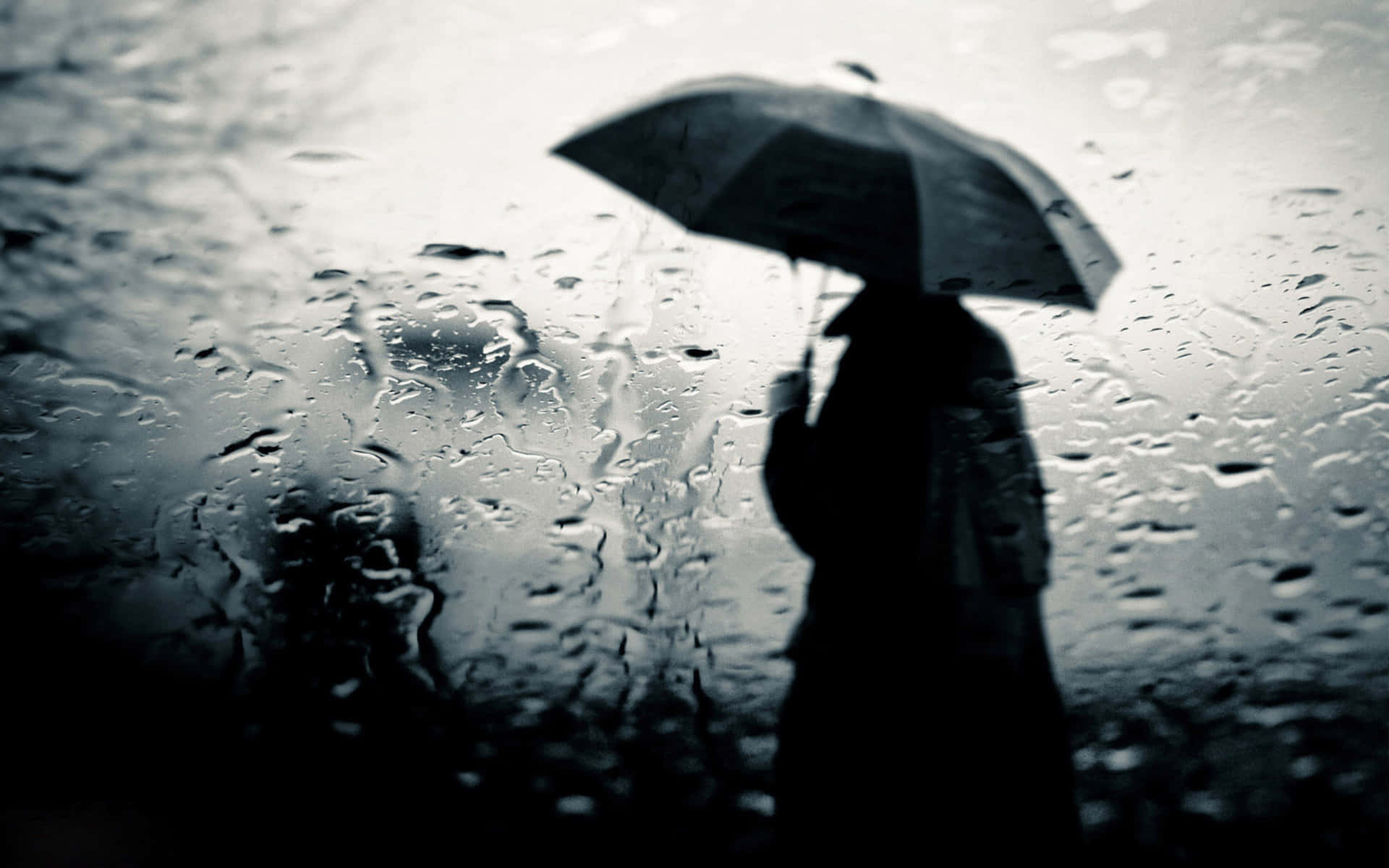 黑白 桌布 壁紙 — 孤獨的身影撐著雨傘，緊靠著雨水淋漓的窗戶，水滴模糊了窗外陰鬱的世界。