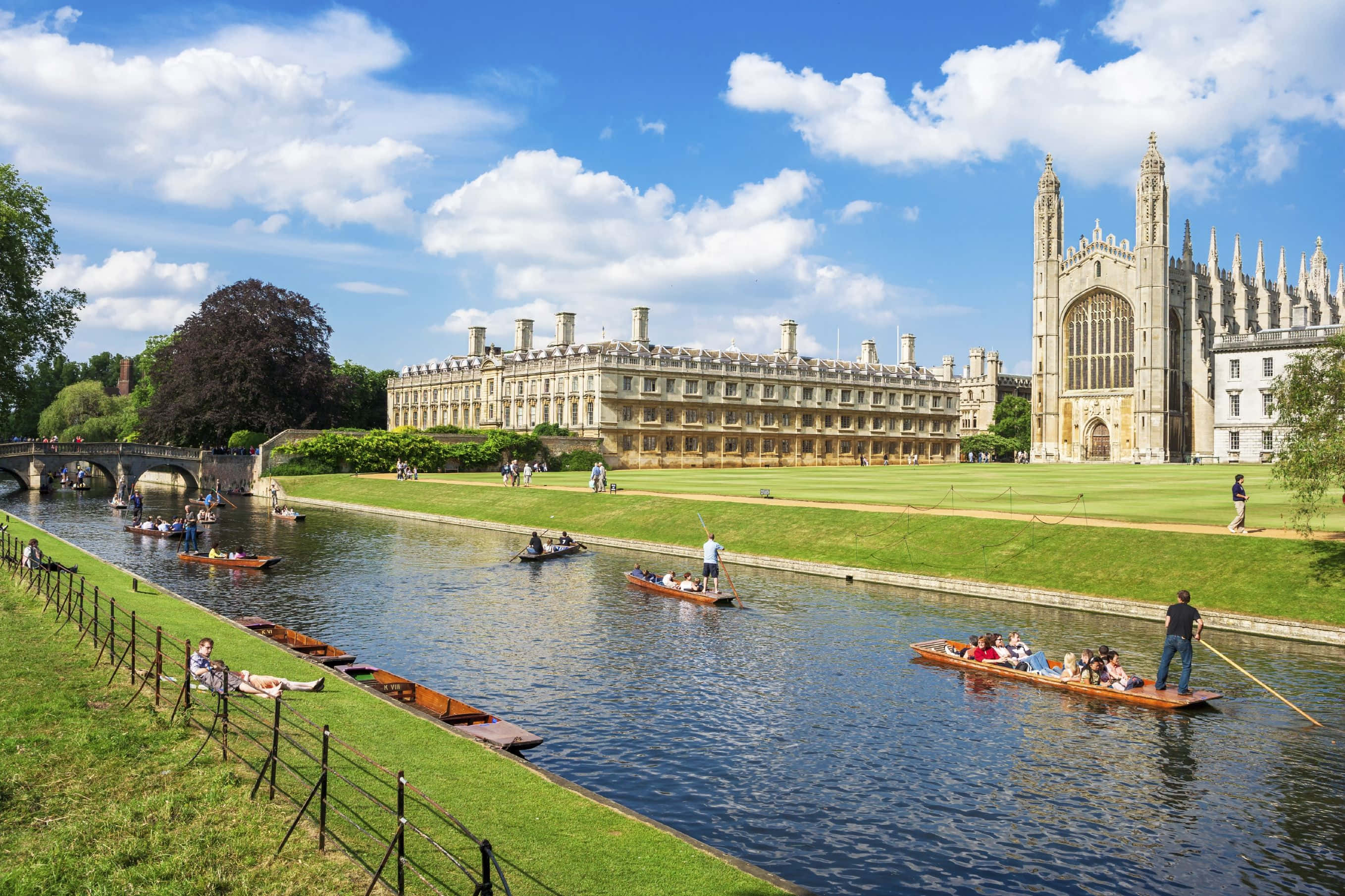 Blue Sky 桌布 壁紙 — 學生和遊客在明亮的藍天白雲下，沿著寧靜的劍河撐船滑行。