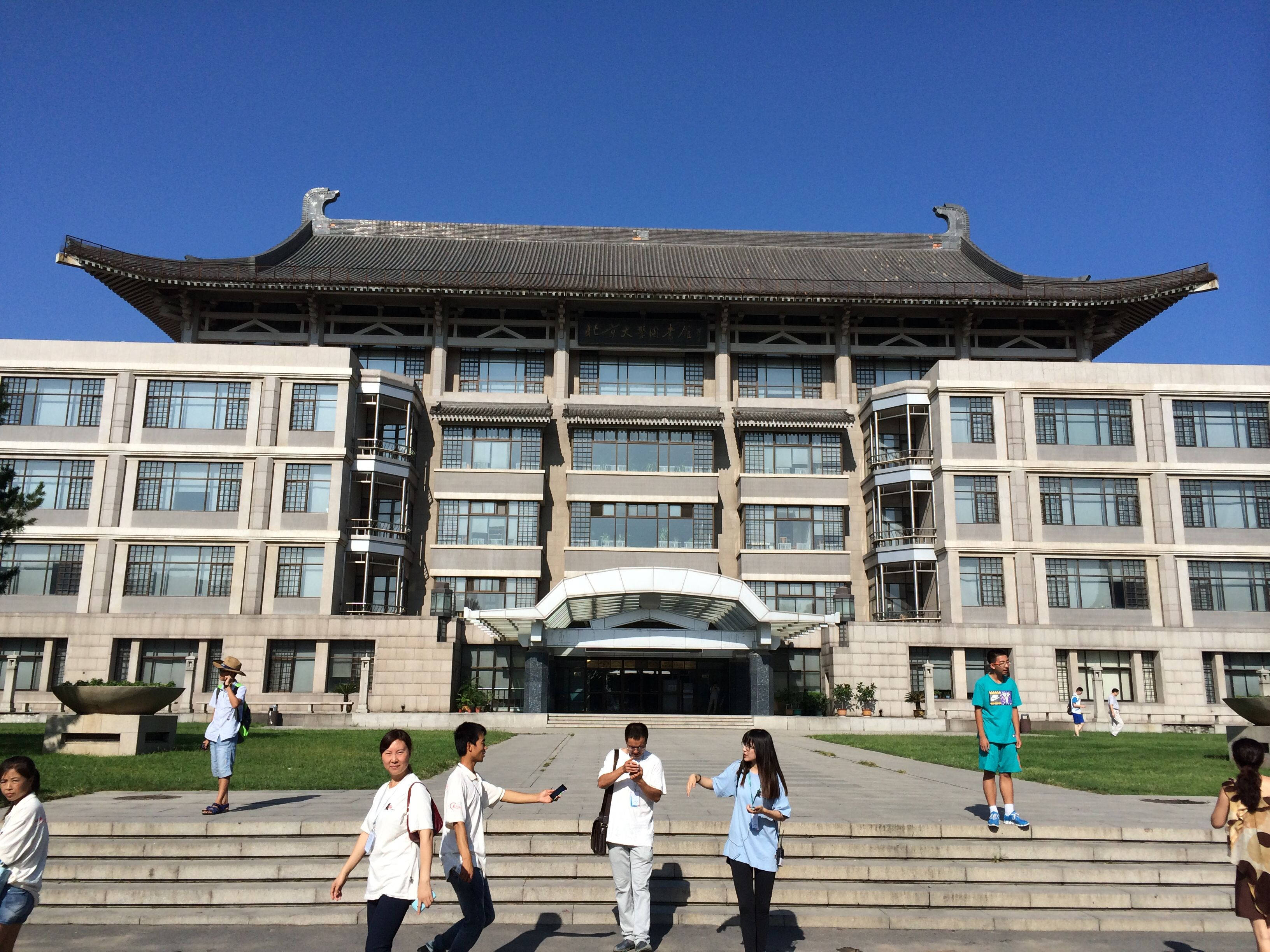 中國 桌布 壁紙 — 學生在晴朗藍天下，於宏偉傳統風格大學建築前的石階上漫步。