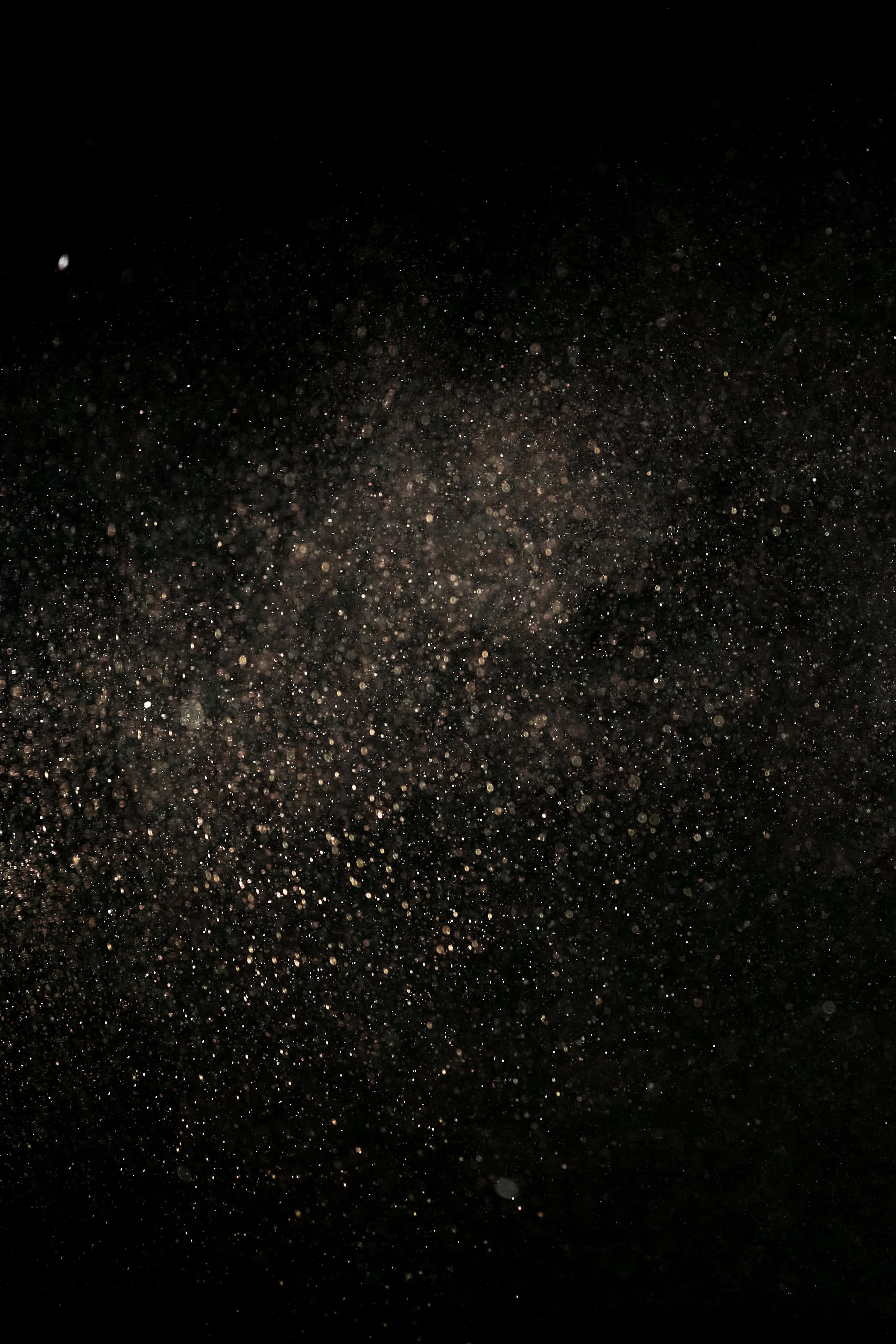 Dust 桌布 壁紙 — 宇宙塵埃雲在深邃的黑色太空中旋轉，閃爍著金色粒子和微弱的星星。