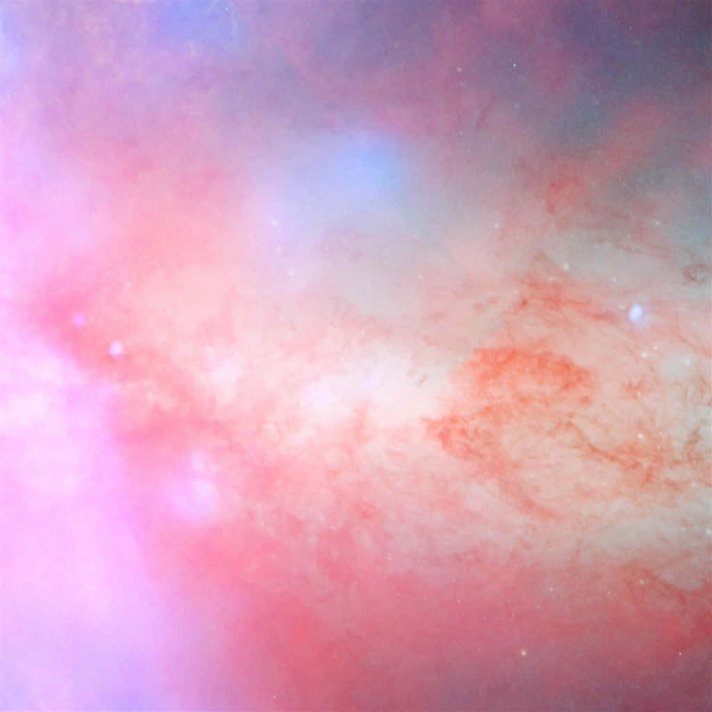 Pink iPad 桌布 壁紙 — 宇宙星雲以柔和的粉紅、藍色和白色旋轉，散落的星星在虛空中輕輕發光。