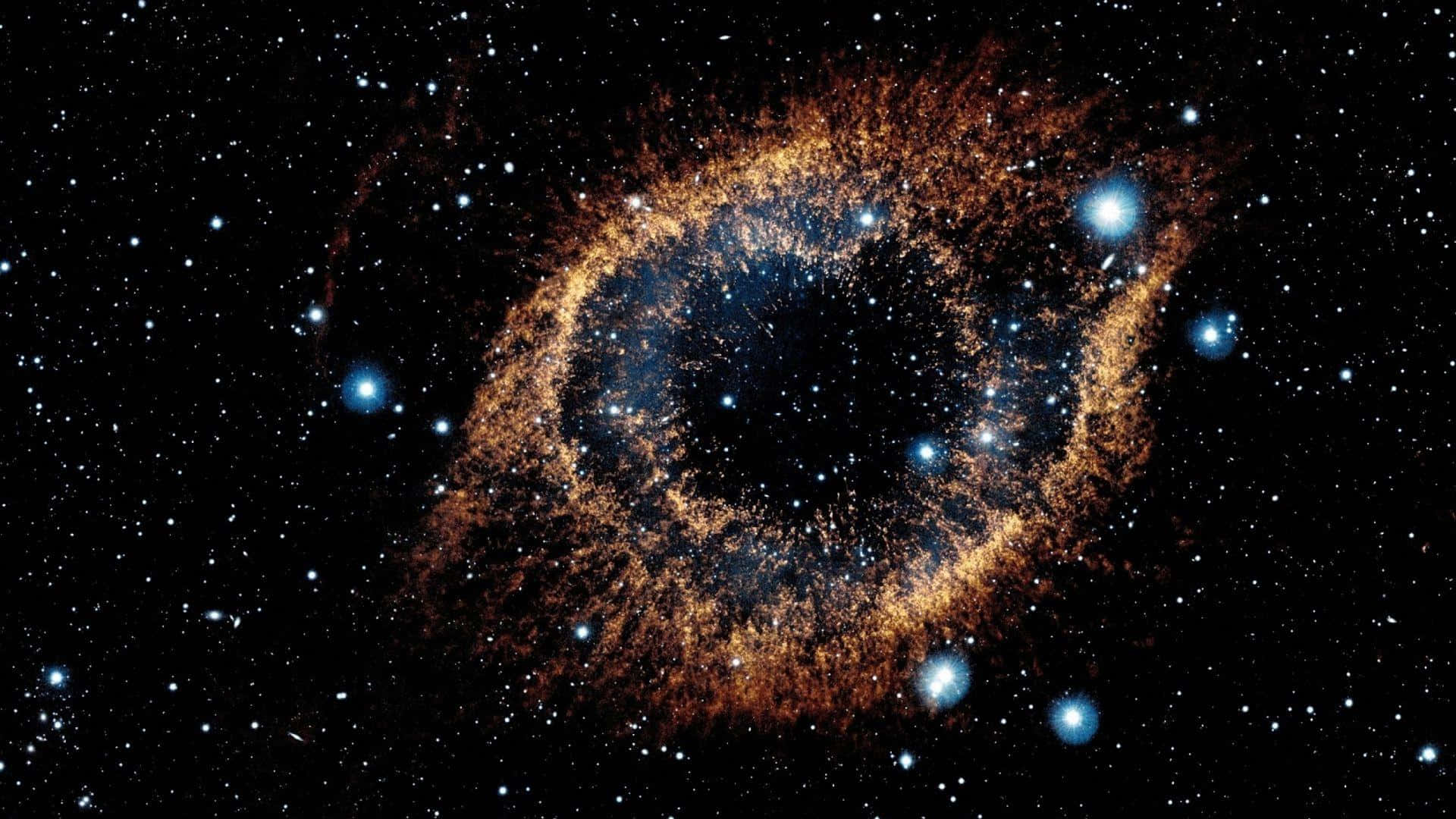 NASA 動態圖片 桌布 壁紙 — 宇宙星雲在星場背景下旋轉，帶有金色塵埃和藍色星星。