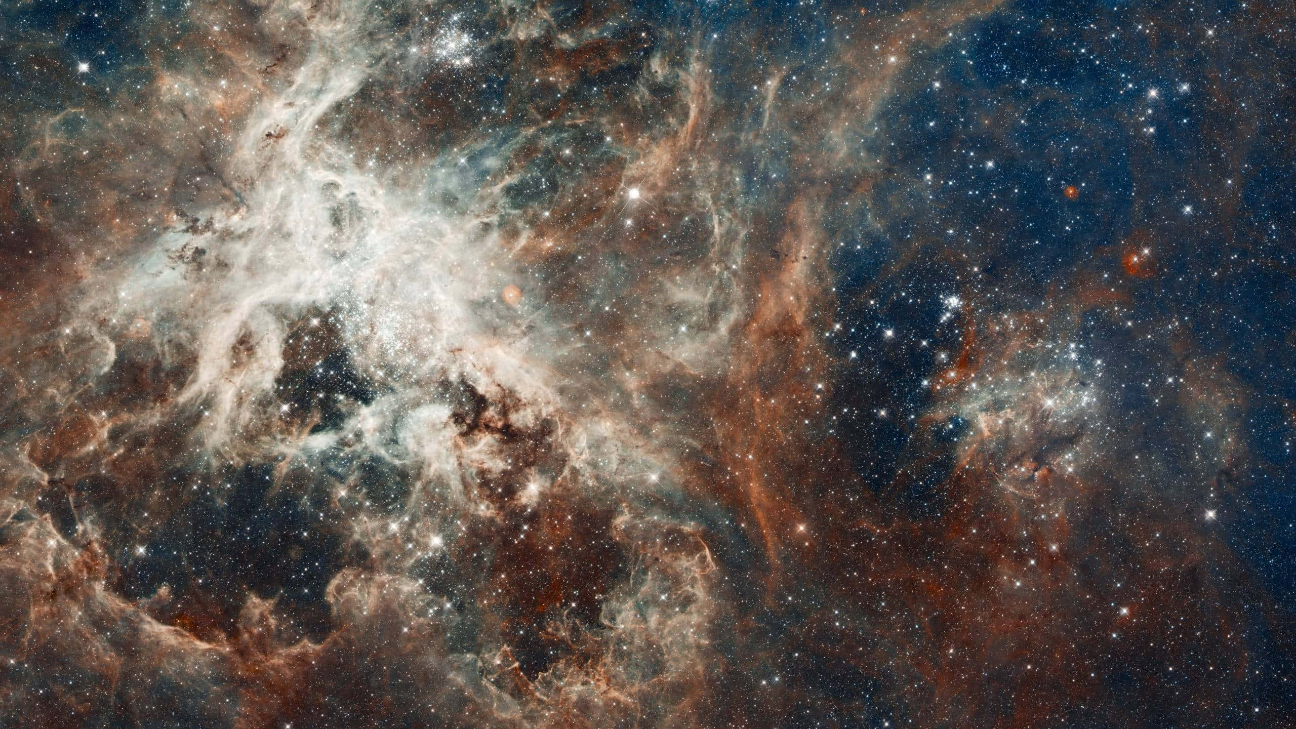 1440p 桌布 壁紙 — 宇宙星雲在深藍色太空的星場背景下旋轉，散發著橙色和白色的發光氣體雲。