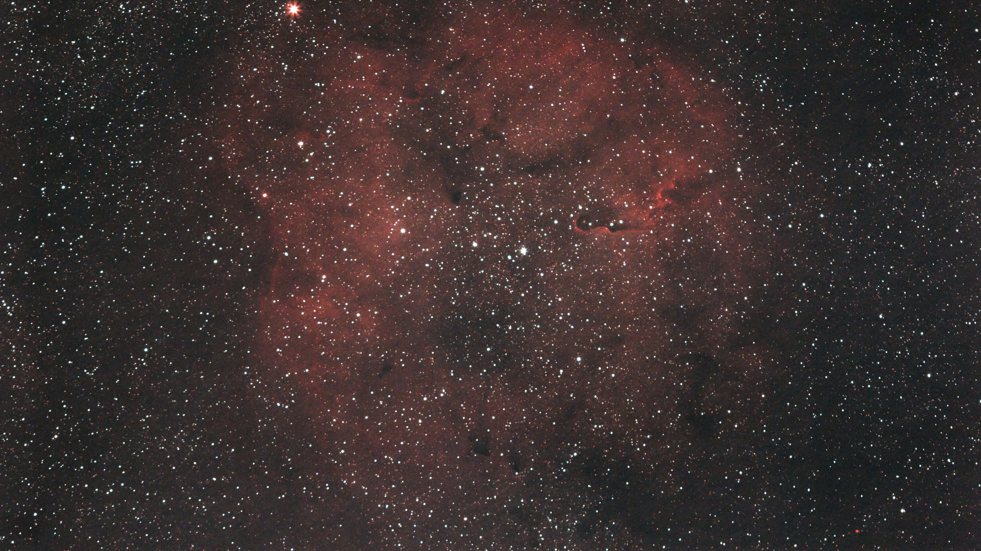紅色動圖 桌布 壁紙 — 宇宙景觀，發光的紅色星雲和無數星星散佈在深邃的黑色太空中。