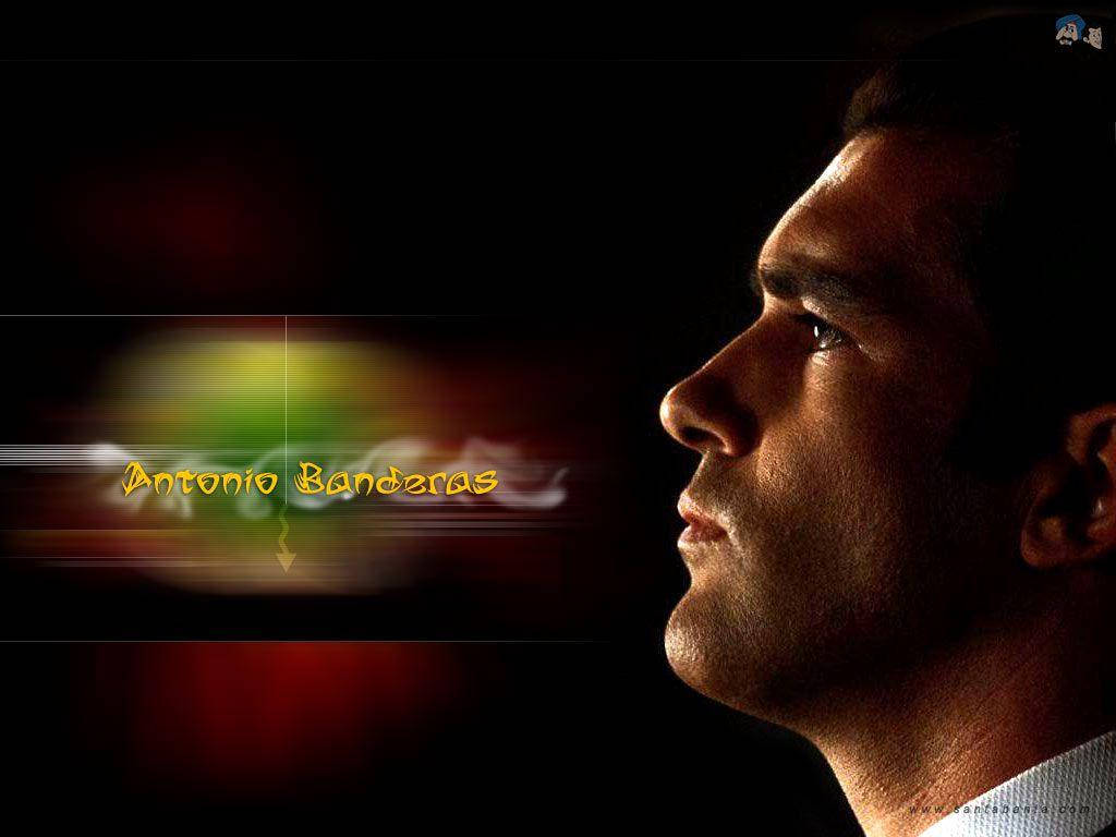 antonio banderas 桌布 壁紙 — 安東尼奧·班德拉斯的戲劇性側面輪廓，被溫暖的光線照亮，背景為深色並帶有彩色動態模糊。