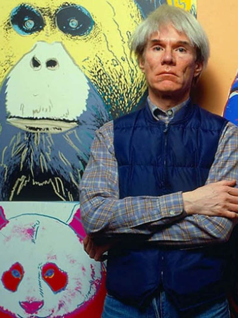 andy warhol 桌布 壁紙 — 安迪·沃荷交叉雙臂站在他色彩繽紛的普普藝術動物畫作前，畫作中有大猩猩和熊貓。