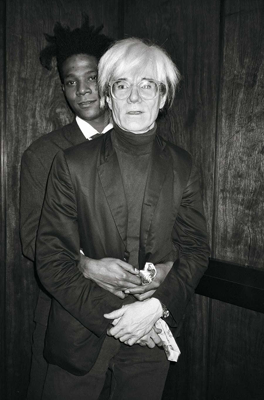 andy warhol 桌布 壁紙 — 安迪·沃荷與一名年輕男子在木牆前的黑白照片中緊密站立。