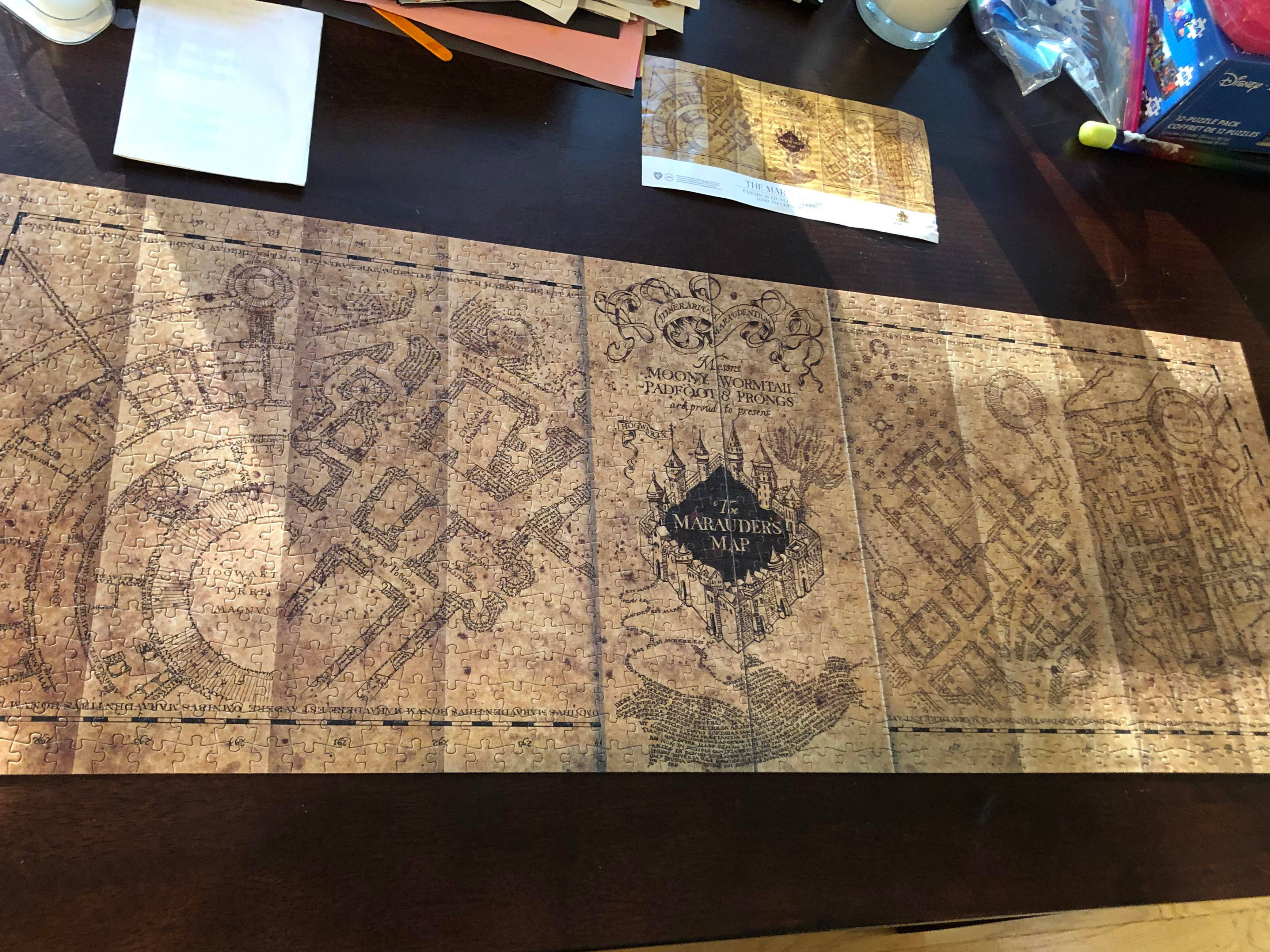Map 桌布 壁紙 — 完成的劫盜地圖拼圖平放在深色木桌上，周圍是手工材料。