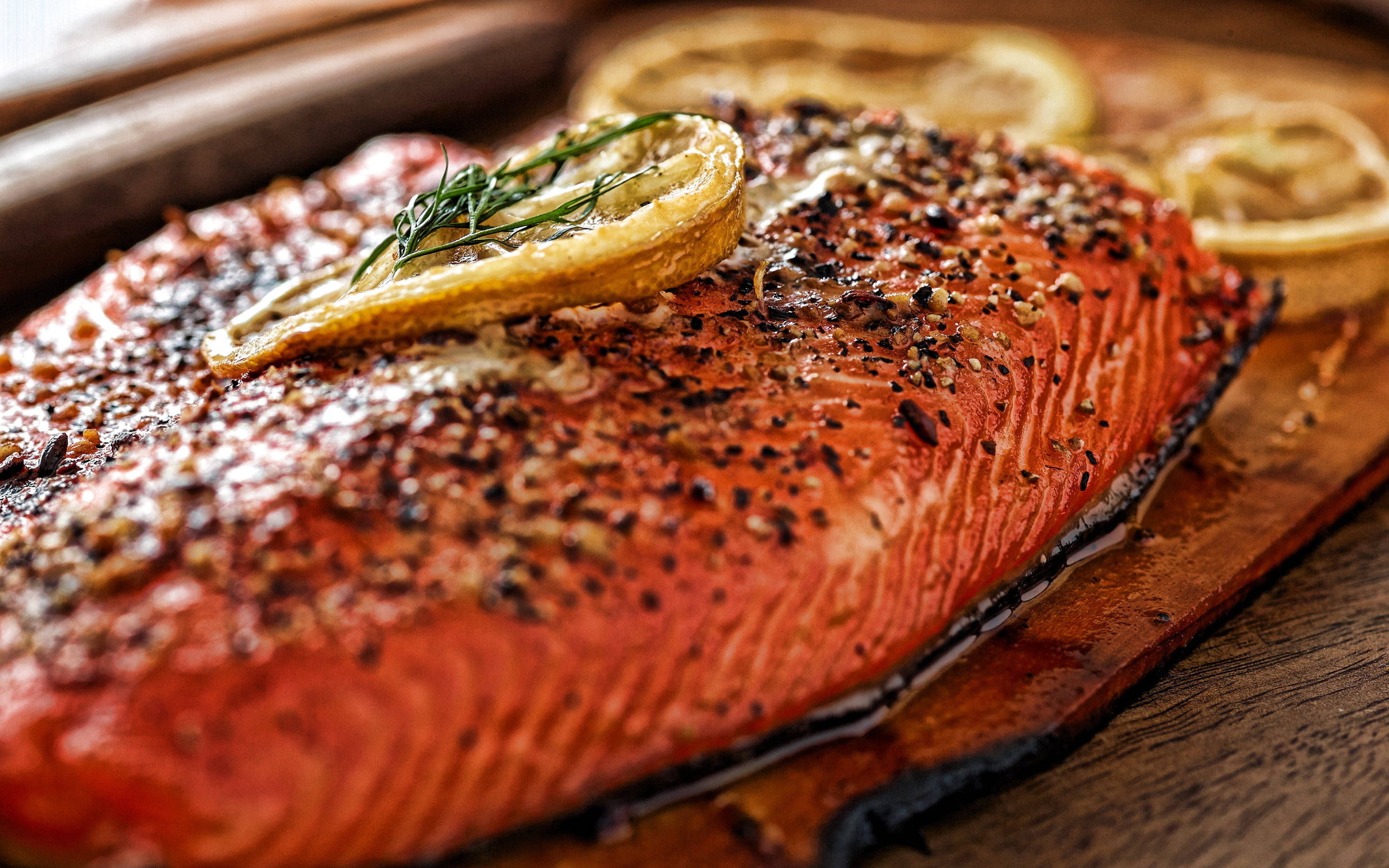 Food Photography 桌布 壁紙 — 完美煎封的鮭魚菲力，搭配香草和檸檬片，在質樸的木板上閃閃發光。