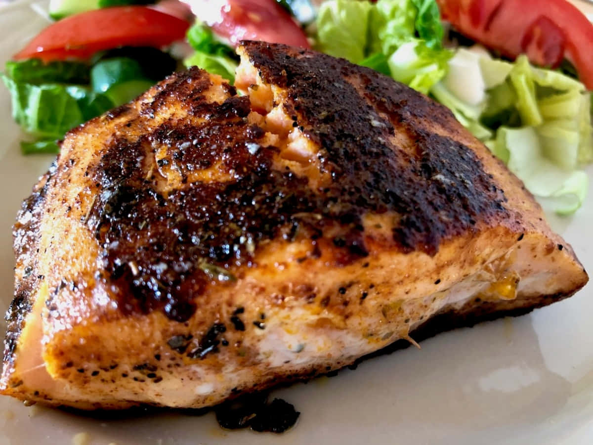 Blackened Chicken 桌布 壁紙 — 完美煎封的鮭魚菲力，魚皮酥脆，放在白色盤子上的新鮮生菜番茄沙拉上。
