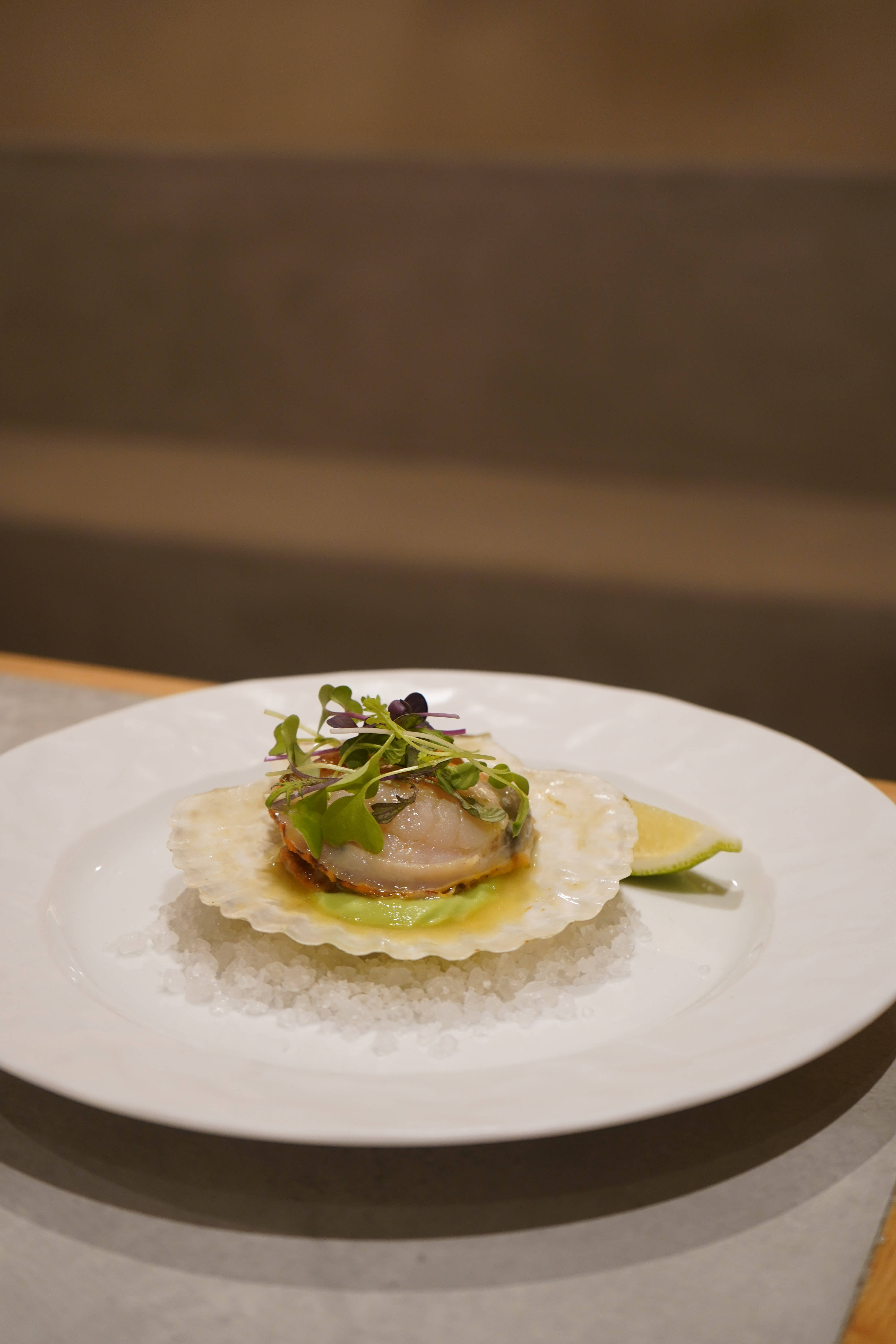 Restaurant 桌布 壁紙 — 完美煎香的干貝放在粗鹽床上，飾以微型蔬菜和萊姆角，置於白盤上。