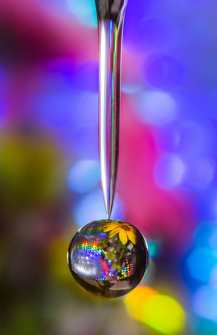 Water Drop 桌布 壁紙 — 完美的玻璃水滴懸掛在反射球體上方，捕捉到充滿活力的散景背景和黃色花朵。