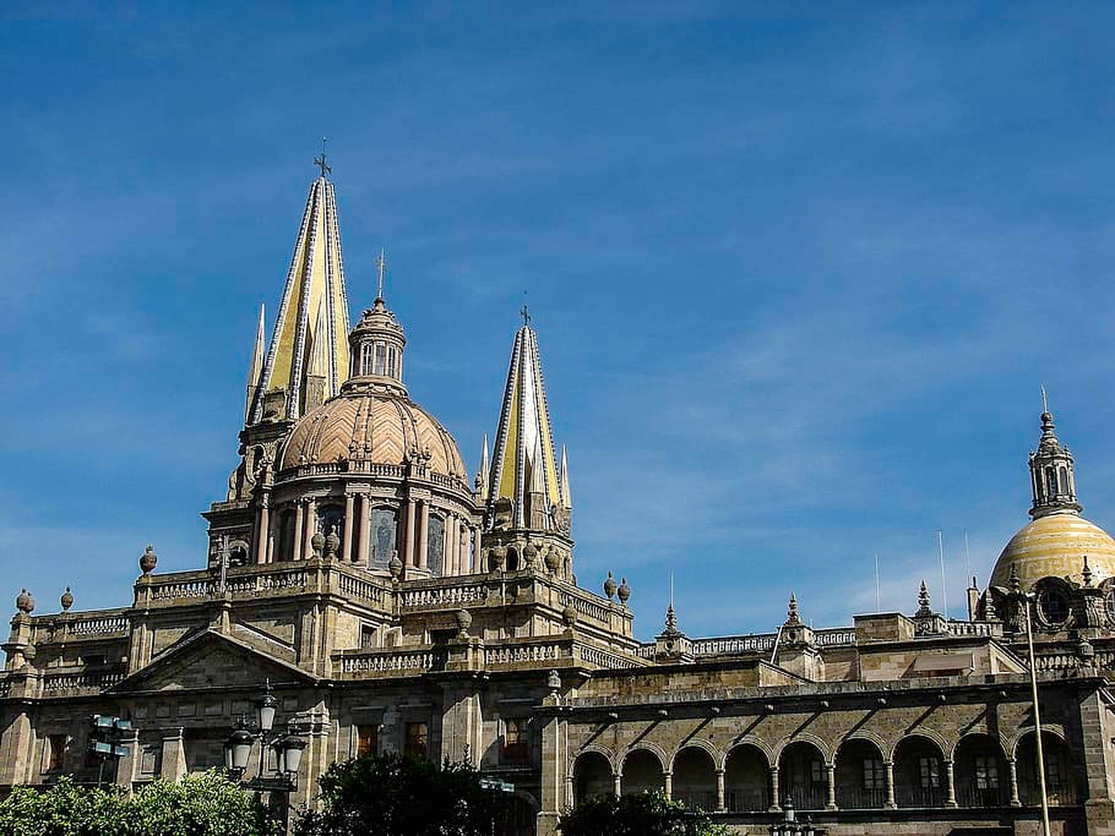 Guadalajara 桌布 壁紙 — 宏偉大教堂，金色尖塔與圓頂在晴朗藍天下、明亮日光中聳立。