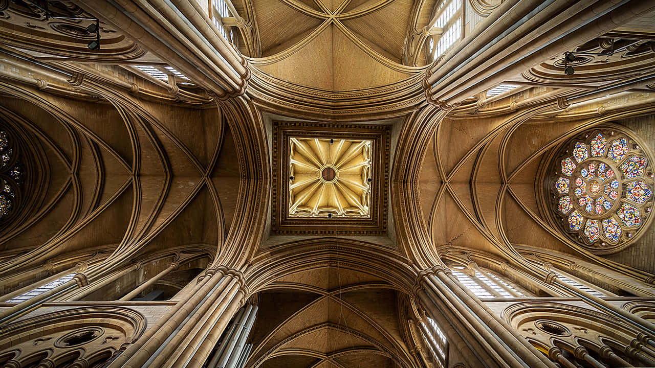 Gothic Architecture 桌布 壁紙 — 宏偉大教堂天花板，帶有複雜的肋拱頂、金色光線和鮮豔的彩繪玻璃玫瑰窗。