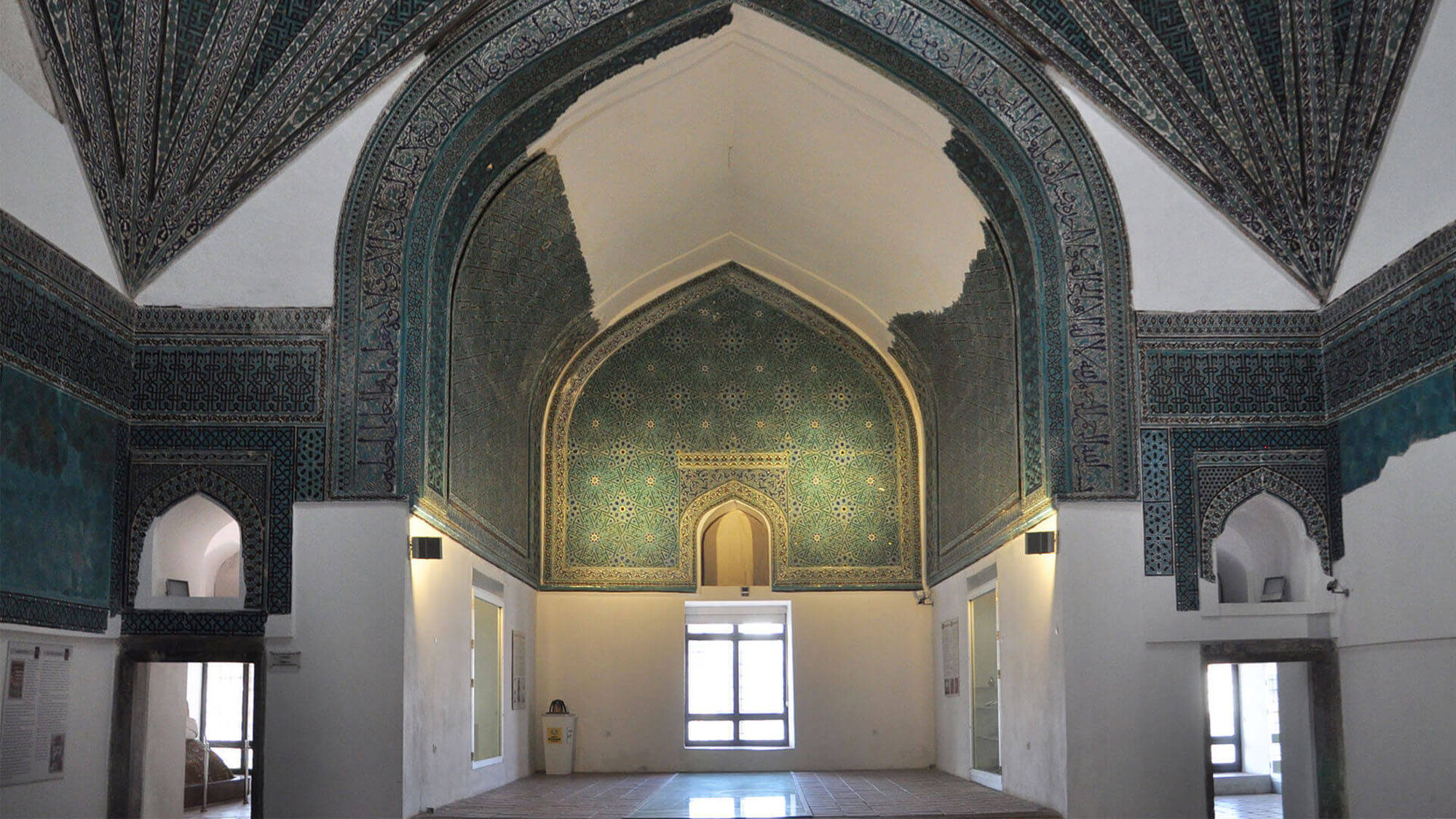 Konya 桌布 壁紙 — 宏偉的伊斯蘭祈禱大廳，擁有精緻的藍綠色瓷磚拱門和拱形天花板，沐浴在柔和自然光中。