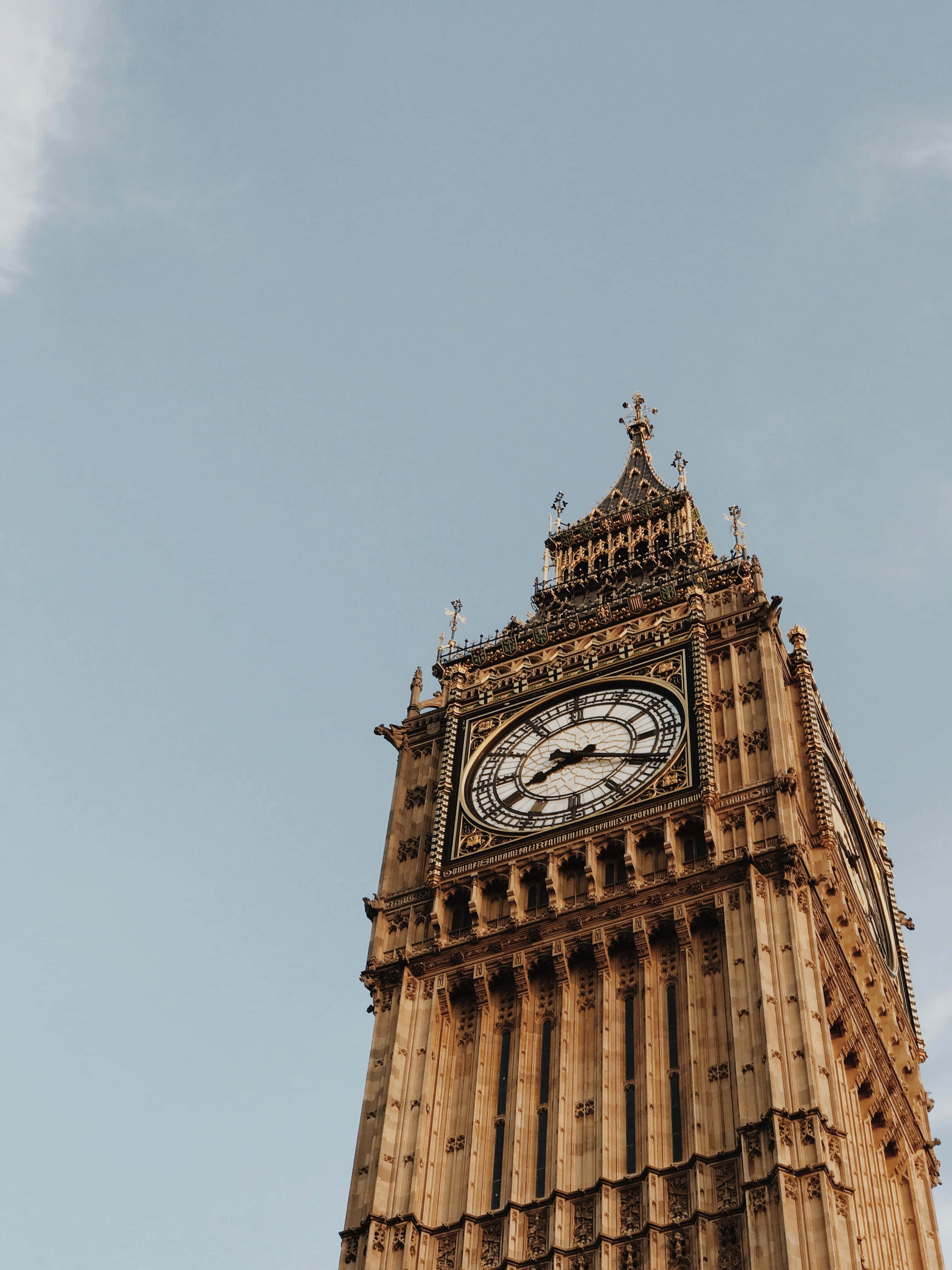 England 桌布 壁紙 — 宏偉的伊麗莎白塔在清澈的藍天下巍然聳立，展現了複雜的哥德式建築和突出的鐘面。