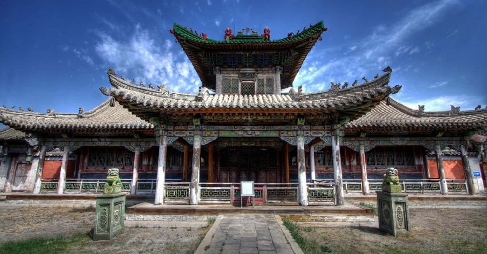 Mongolia 桌布 壁紙 — 宏偉的傳統中國寺廟，擁有華麗的綠色屋頂和石獅雕像，在明亮的藍天下。