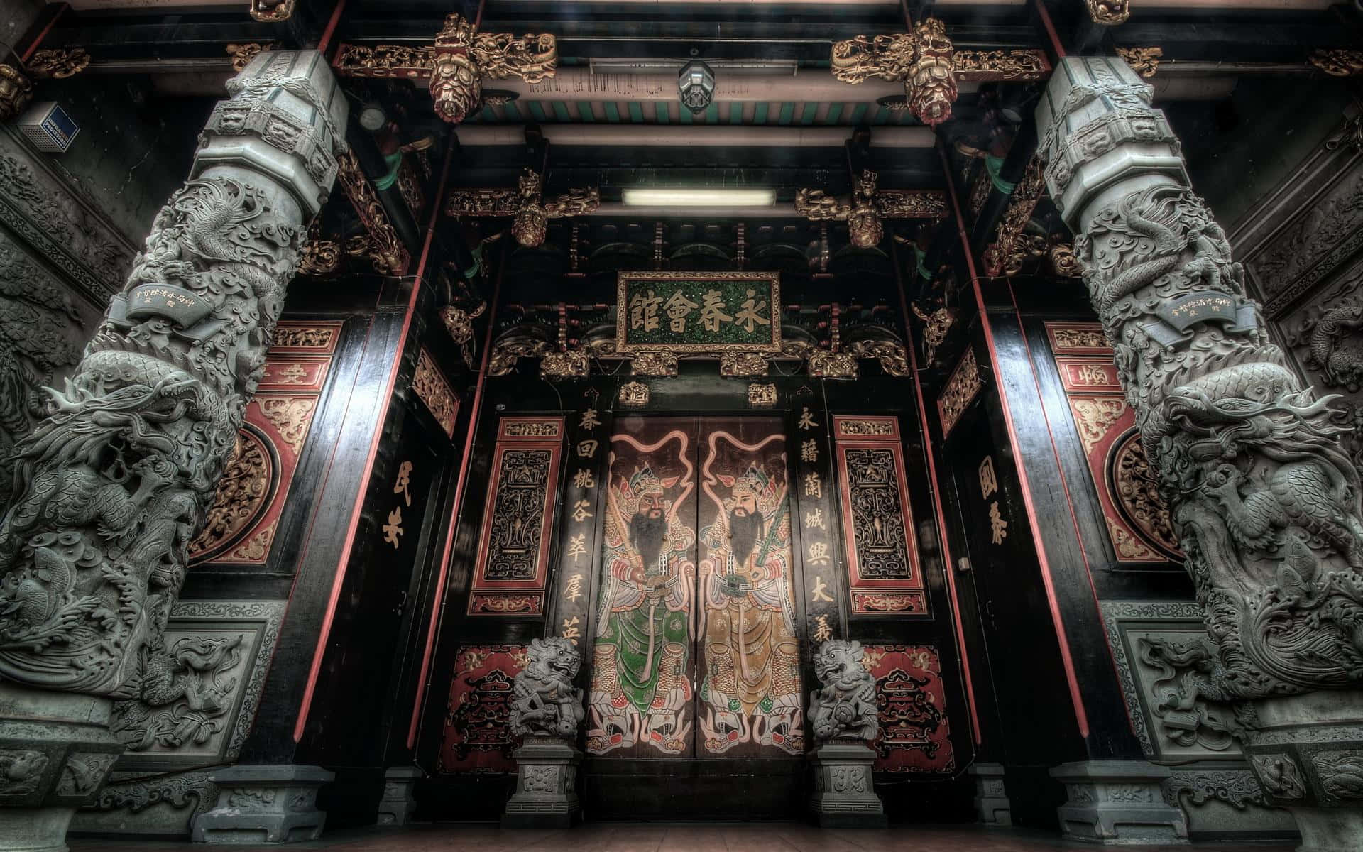 廟宇 桌布 壁紙 — 宏偉的傳統寺廟內部，有精雕細刻的龍柱和華麗的彩繪門，在戲劇性的燈光下。