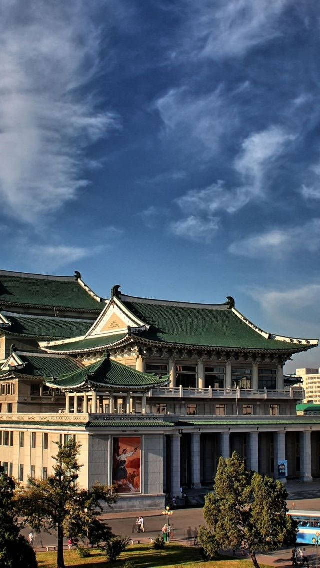 韓國 桌布 壁紙 — 宏偉的傳統建築，擁有綠色瓦片屋頂，在充滿活力的藍天和輕柔雲朵下。