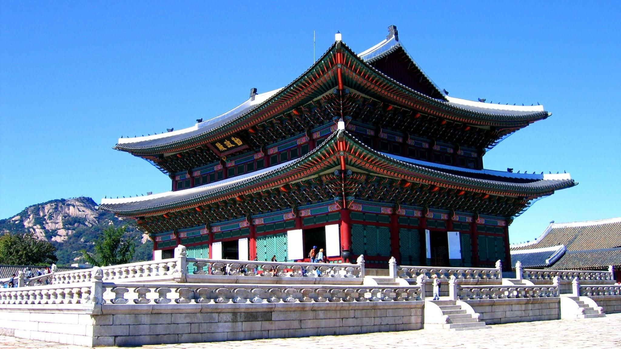 Architecture 桌布 壁紙 — 宏偉的傳統韓國宮殿，擁有寬闊的瓦頂和紅色柱子，在清澈的藍天下。