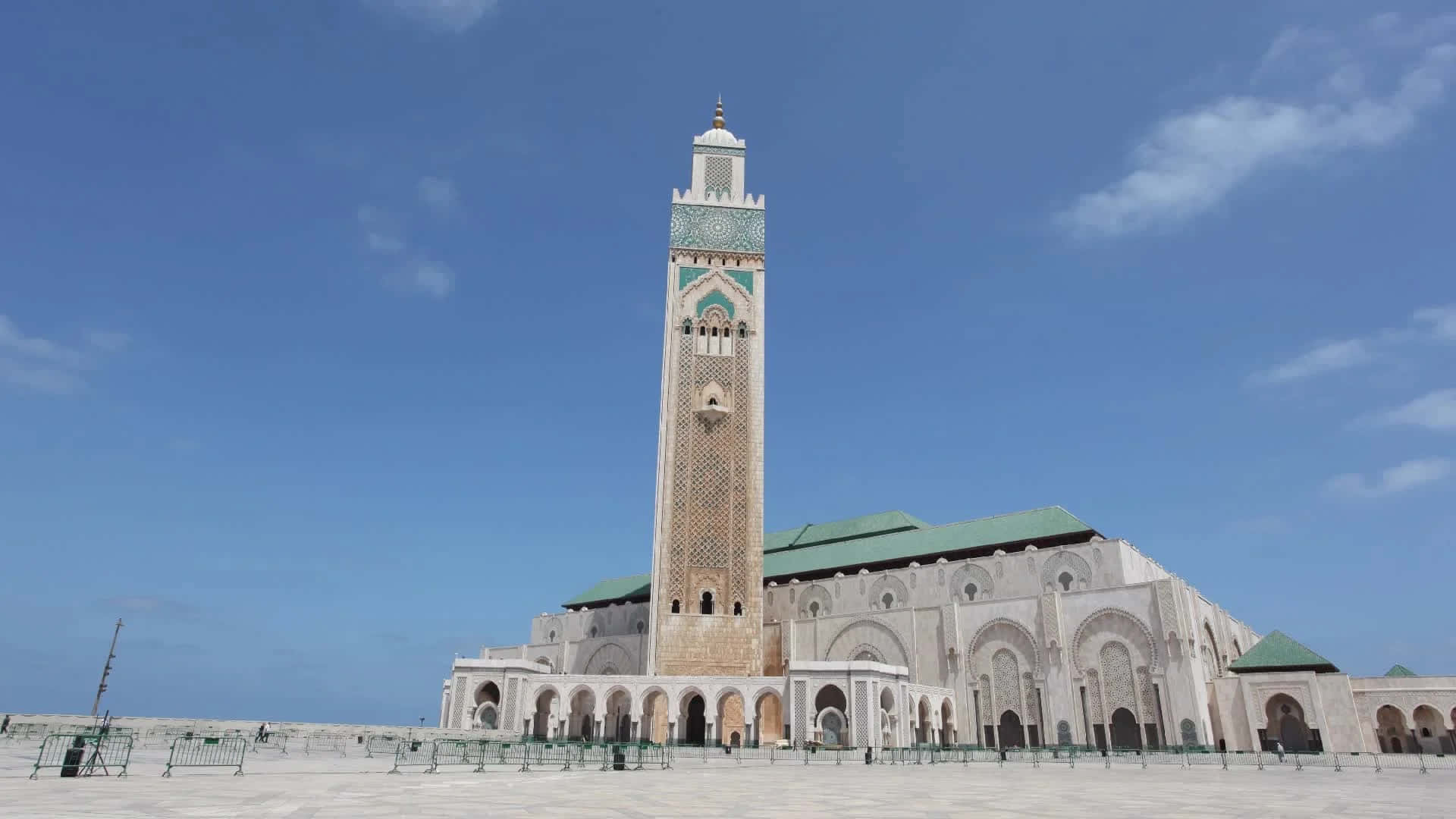 Mosque 桌布 壁紙 — 宏偉的哈桑二世清真寺在清澈的藍天下巍然聳立，高聳的宣禮塔和綠色圓頂在明亮的陽光下閃閃發光。