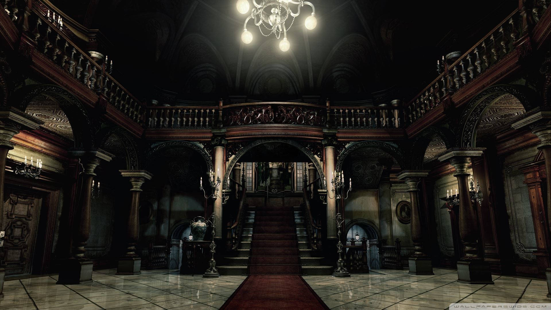 evil 桌布 壁紙 — 宏偉的哥德式大宅門廳，鋪有紅色地毯的樓梯，吊燈在深色木材和石頭上投射出溫暖的光芒。