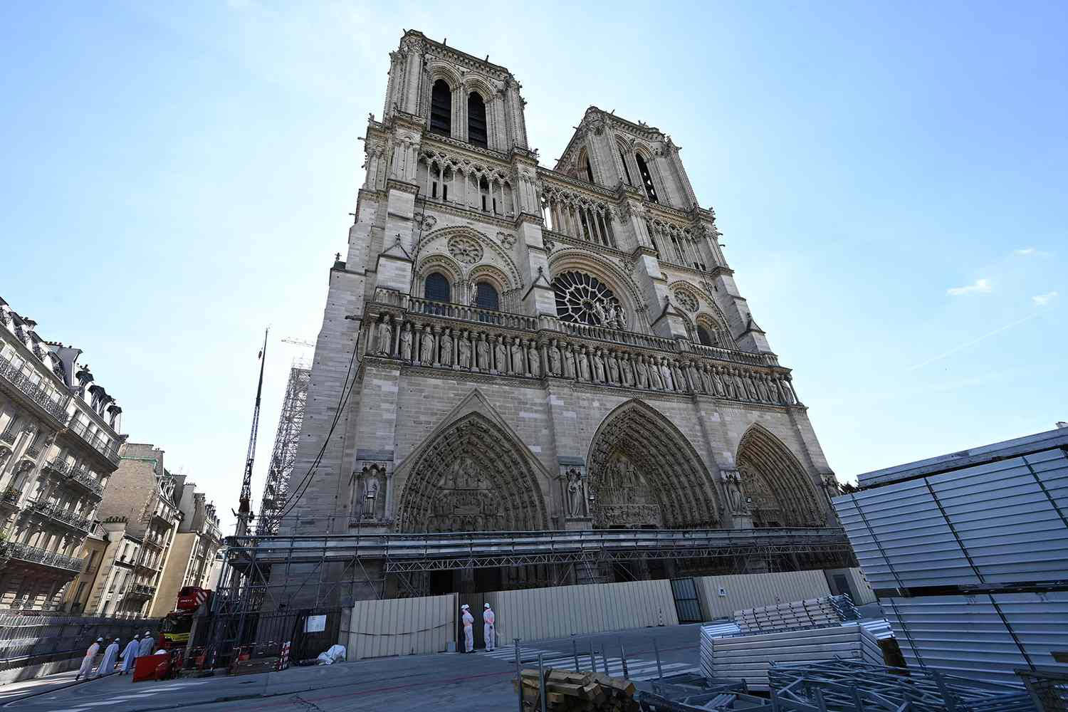 Notre Dame 桌布 壁紙 — 宏偉的哥德式聖母院大教堂正在修復中，鷹架襯托著清澈的藍天。