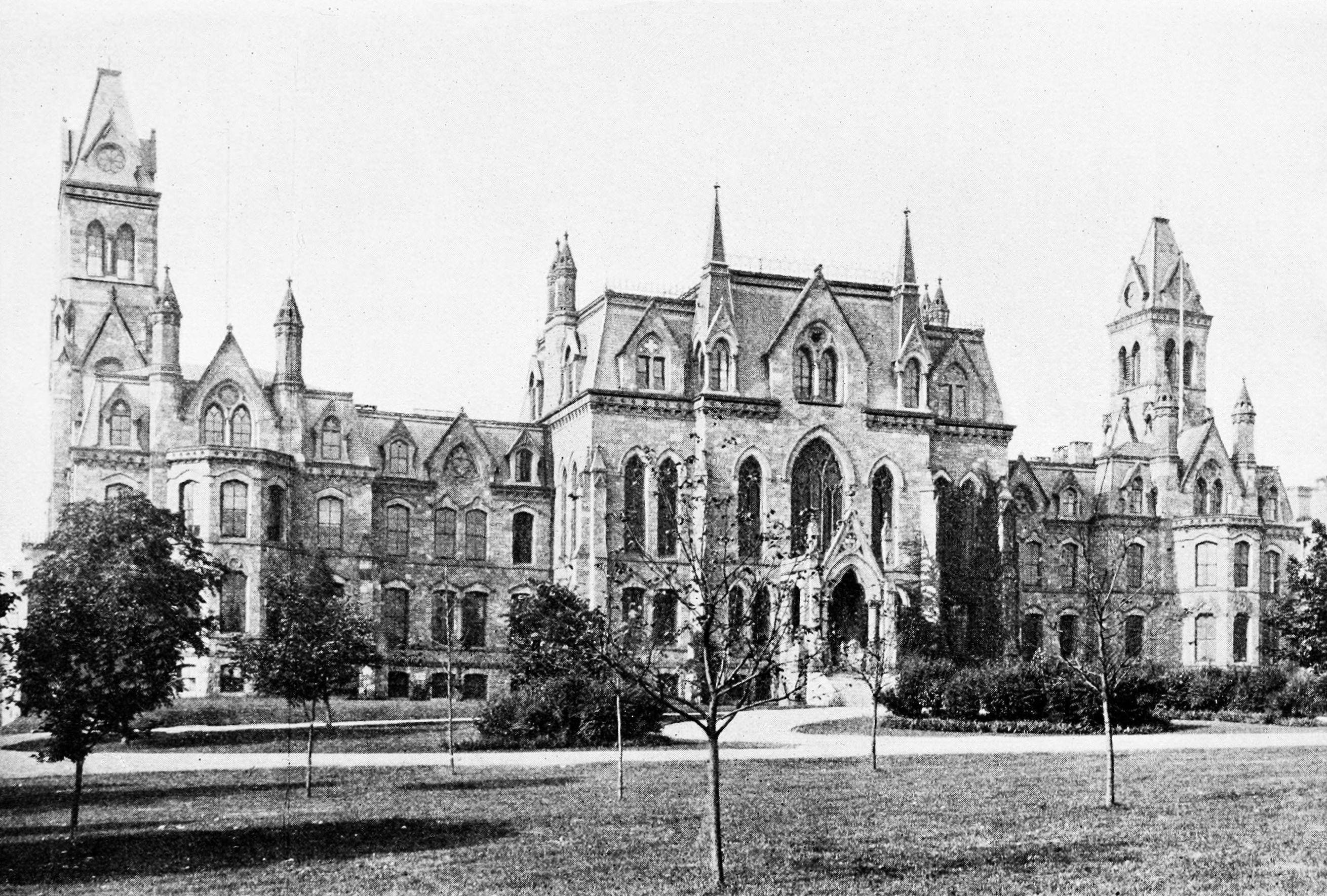 University Of Pennsylvania 桌布 壁紙 — 宏偉的哥德復興式大學建築，擁有尖頂和拱形窗戶，在修剪整齊的草坪和枝葉繁茂的樹木中巍然聳立。
