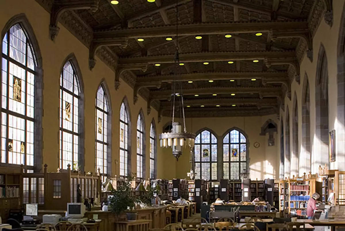 Library 桌布 壁紙 — 宏偉的圖書館，擁有高聳的拱形窗戶、彩色玻璃和木樑，沐浴在溫暖的午後陽光中。