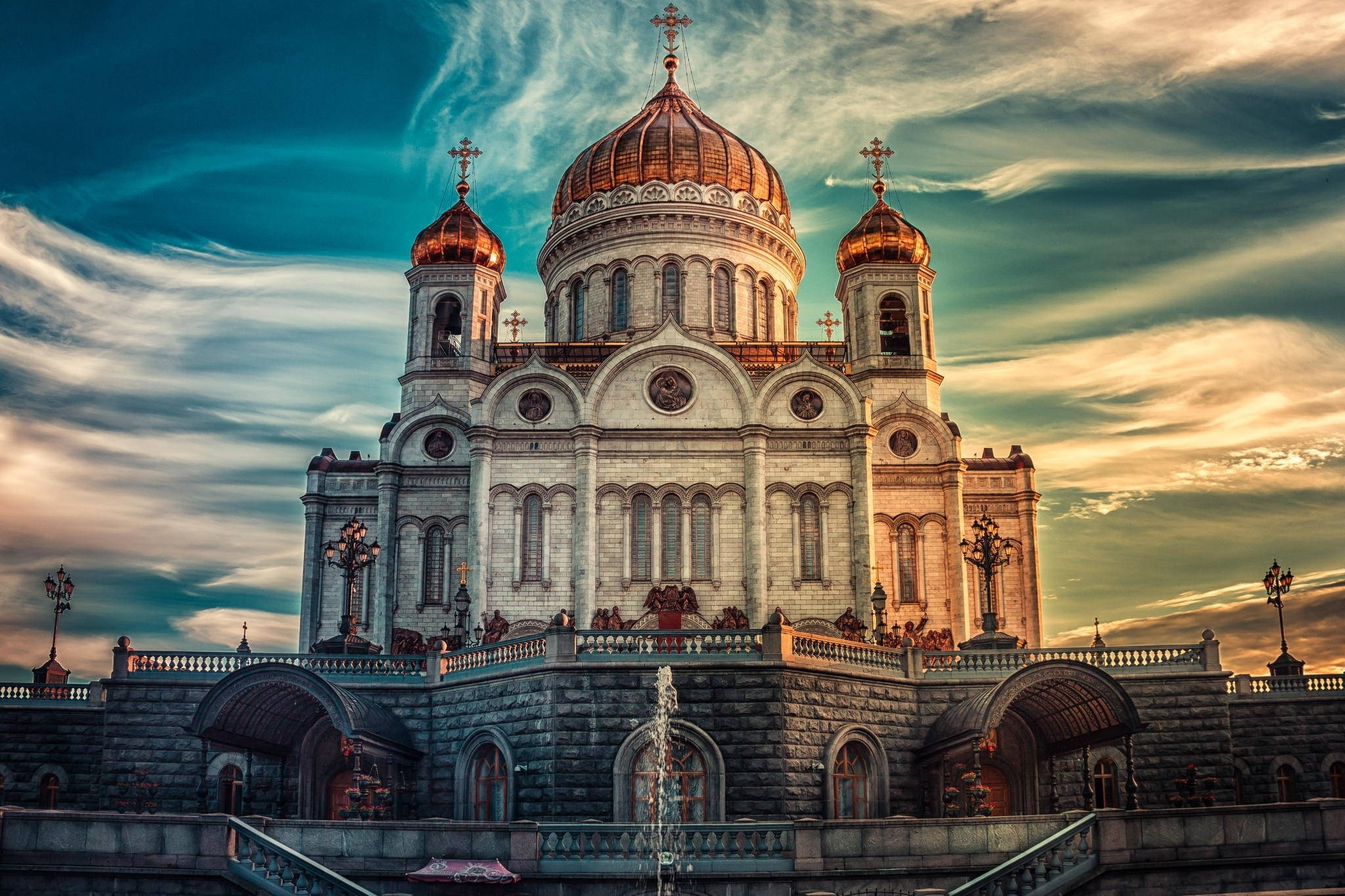 Russia 桌布 壁紙 — 宏偉的大教堂，金色圓頂和十字架在戲劇性的日落天空下巍然聳立。