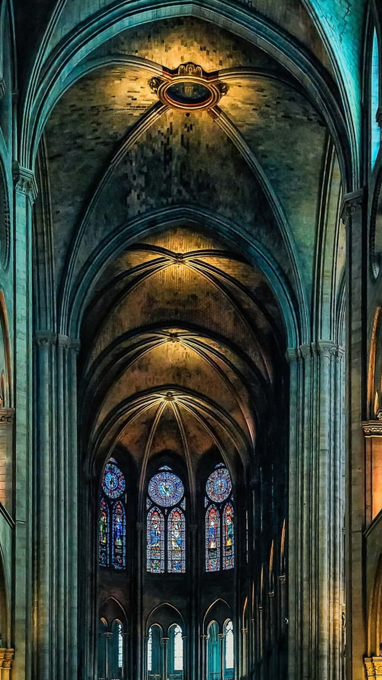 Notre Dame 桌布 壁紙 — 宏偉的大教堂內部，擁有高聳的石拱頂、彩繪玻璃窗和溫暖的金色燈光。