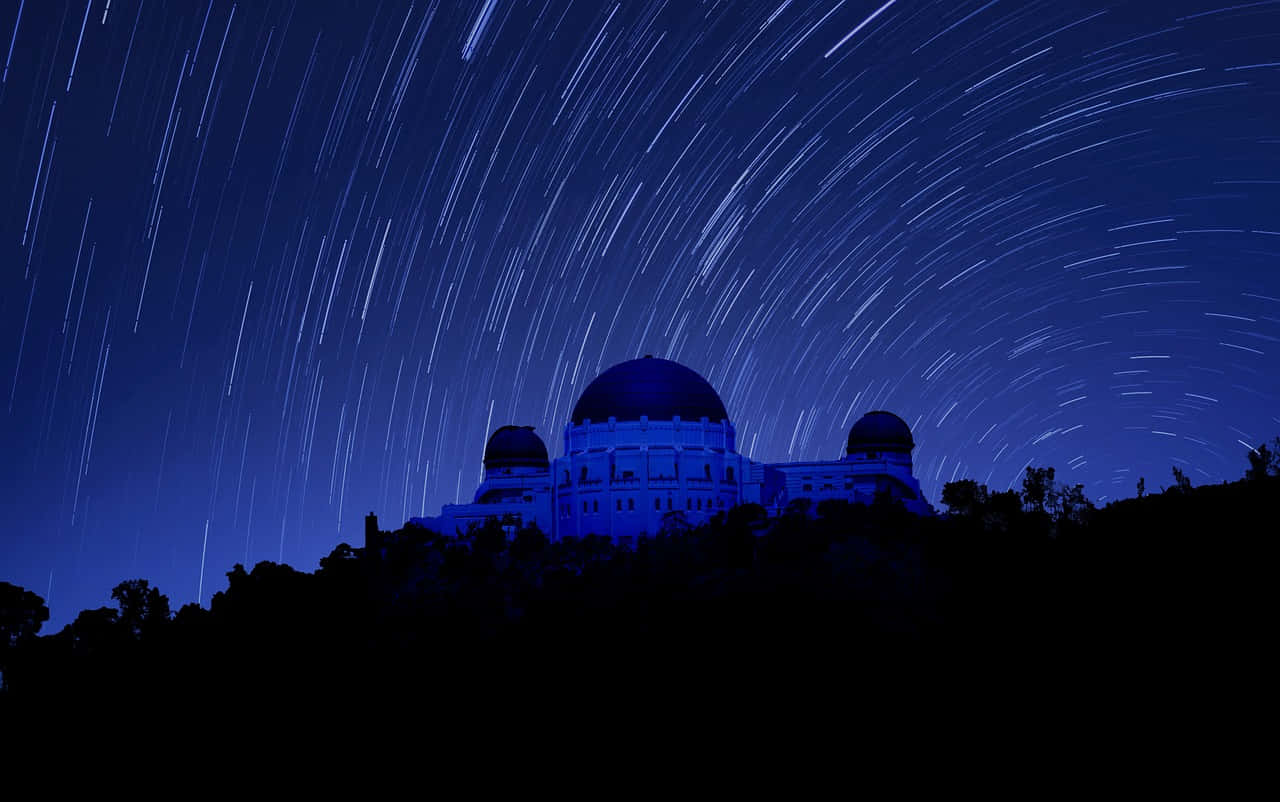 Observatory 桌布 壁紙 — 宏偉的天文台在深藍色天空襯托下呈現剪影，天空佈滿鮮豔的星軌。