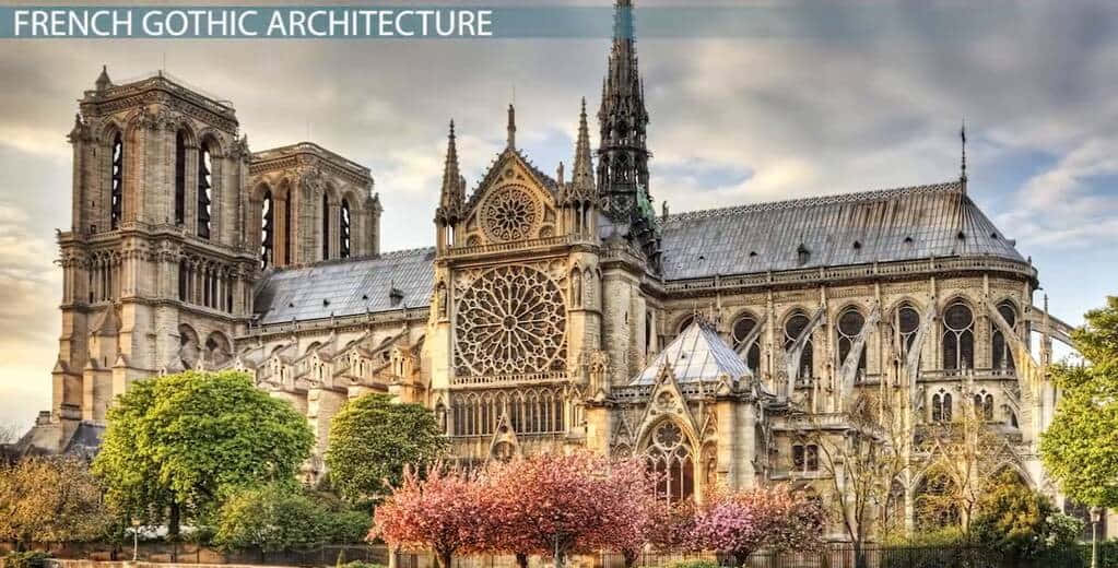 Gothic Architecture 桌布 壁紙 — 宏偉的巴黎聖母院大教堂，擁有精緻的石雕尖塔和玫瑰窗，在陰天背景下被盛開的粉紅色樹木環繞。
