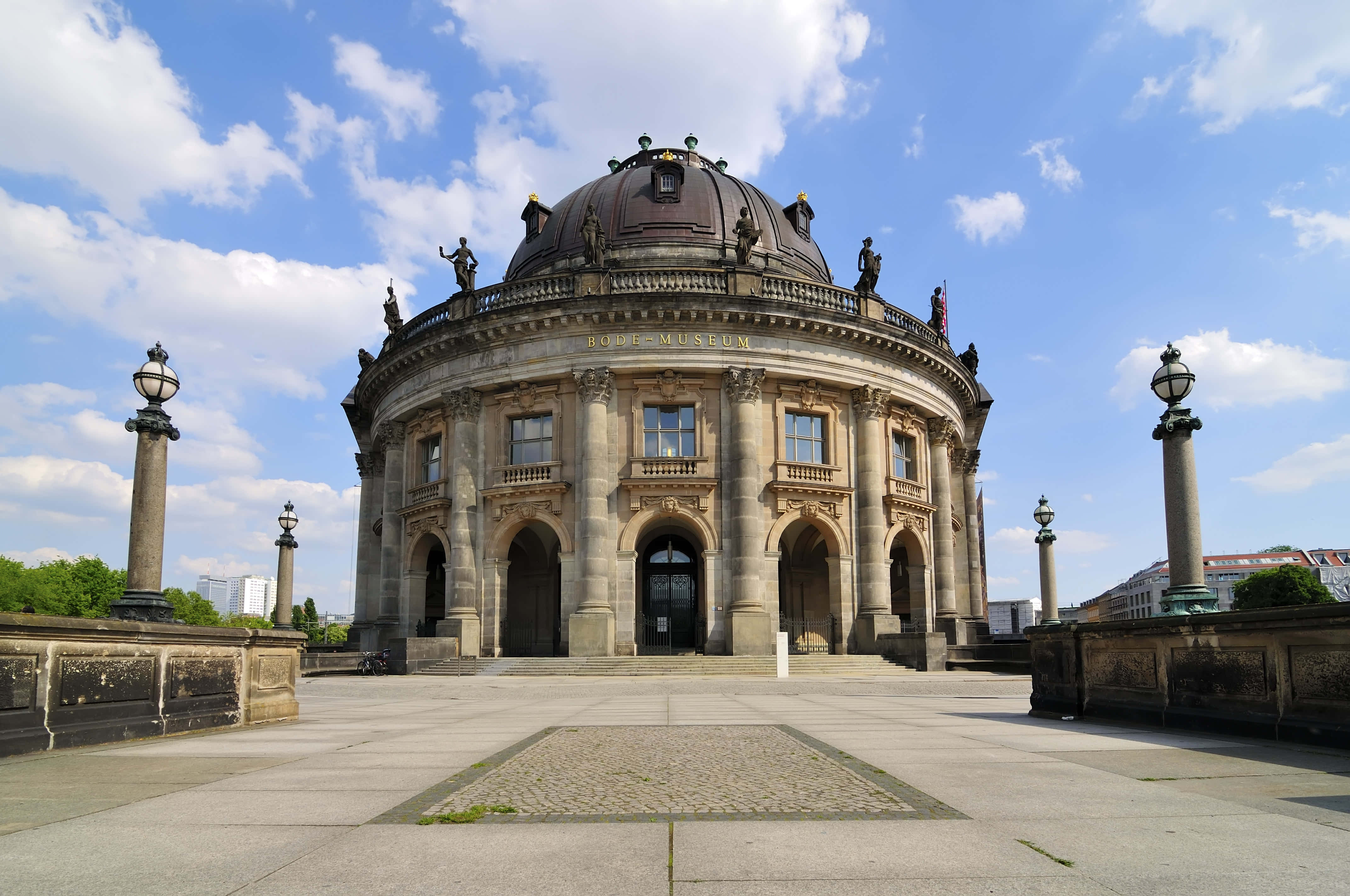 Berlin 桌布 壁紙 — 宏偉的新古典主義圓頂博物館矗立在明亮的藍天下，有蓬鬆的白雲和石柱，兩側是寬闊的廣場。