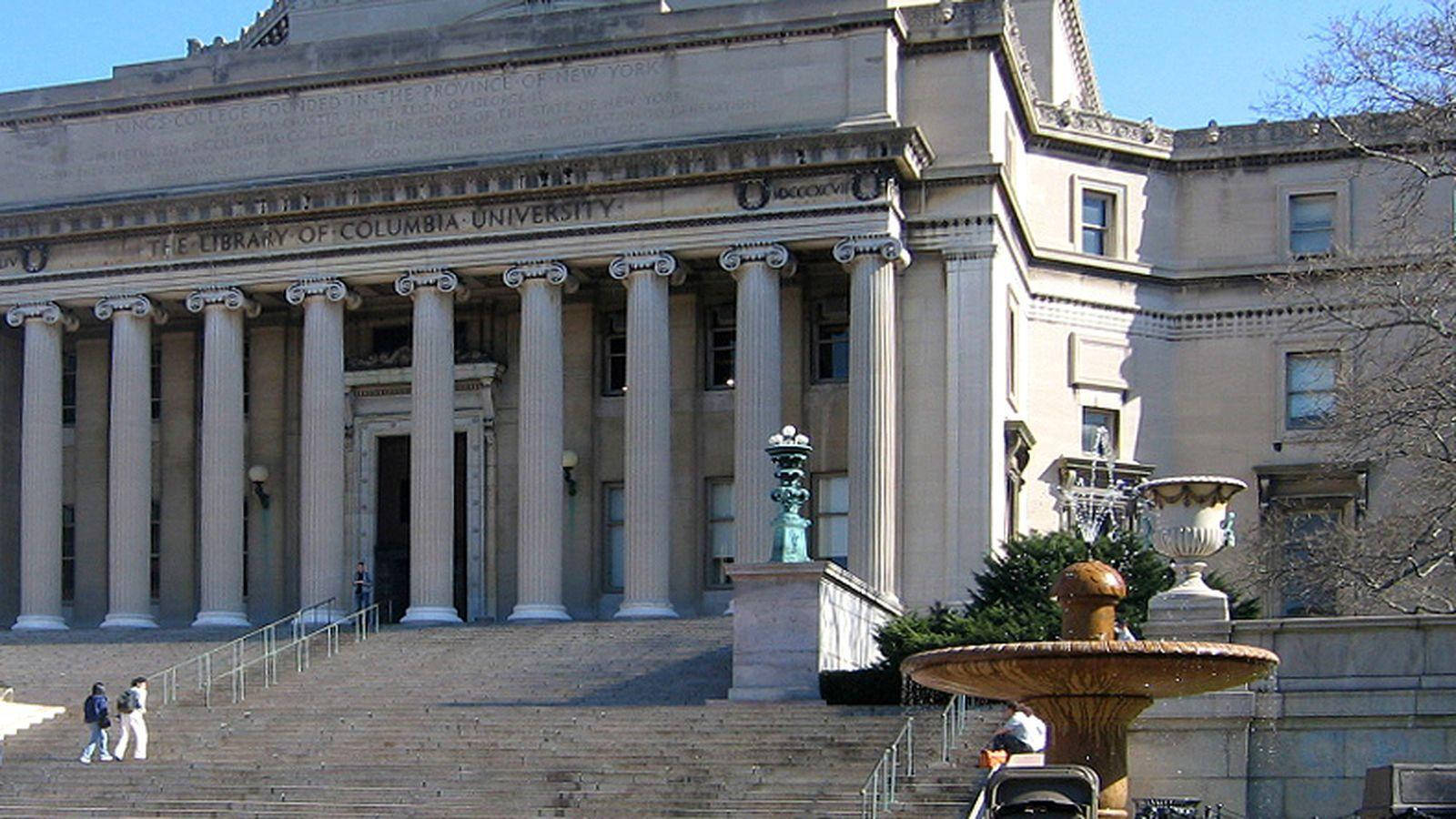 Library 桌布 壁紙 — 宏偉的新古典主義圖書館建築，擁有高大的柱子和石階，在明亮的日光下。