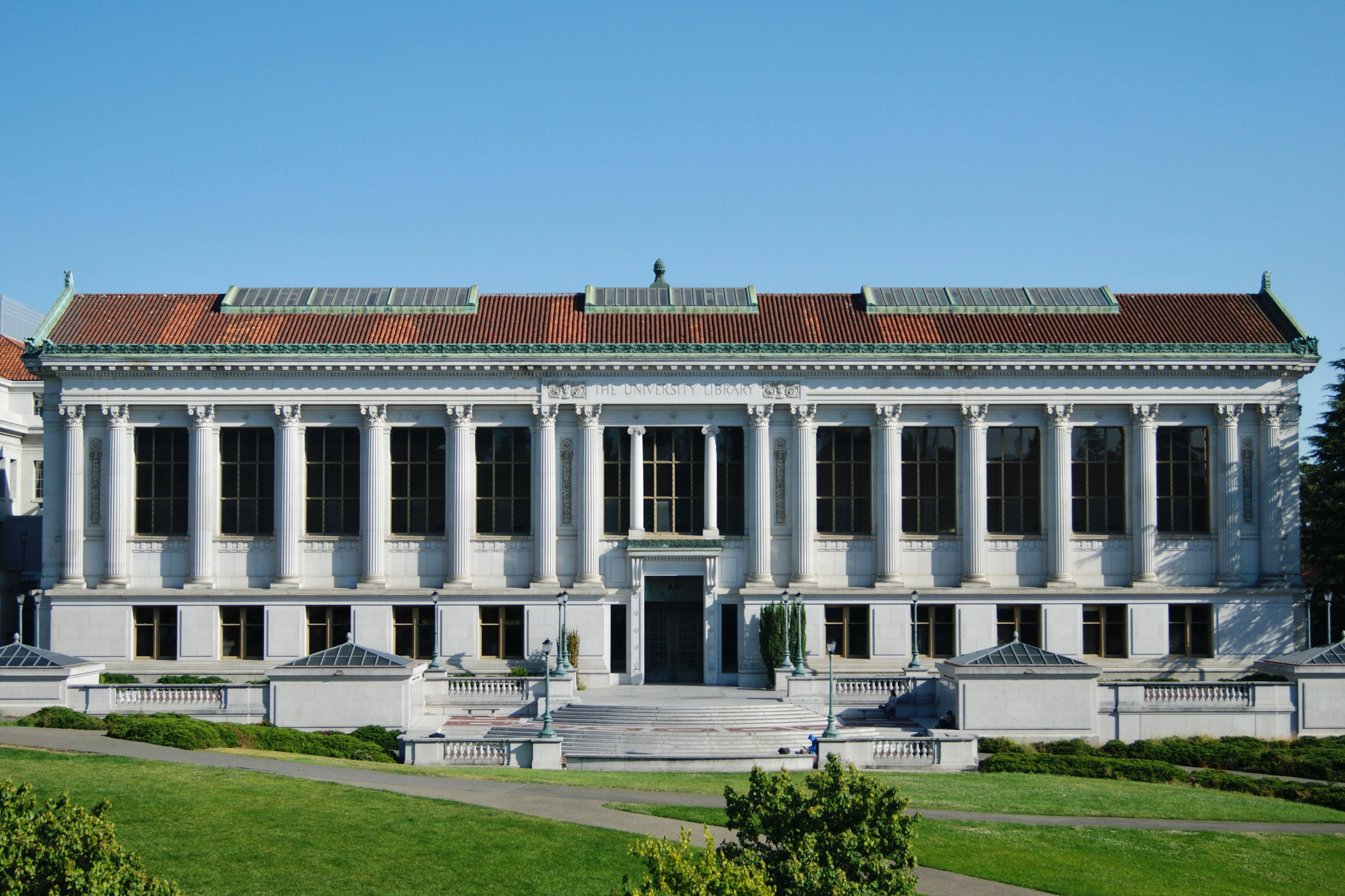 加州 桌布 壁紙 — 宏偉的新古典主義圖書館建築，白色柱子和紅色瓦頂，在晴朗的藍天下。