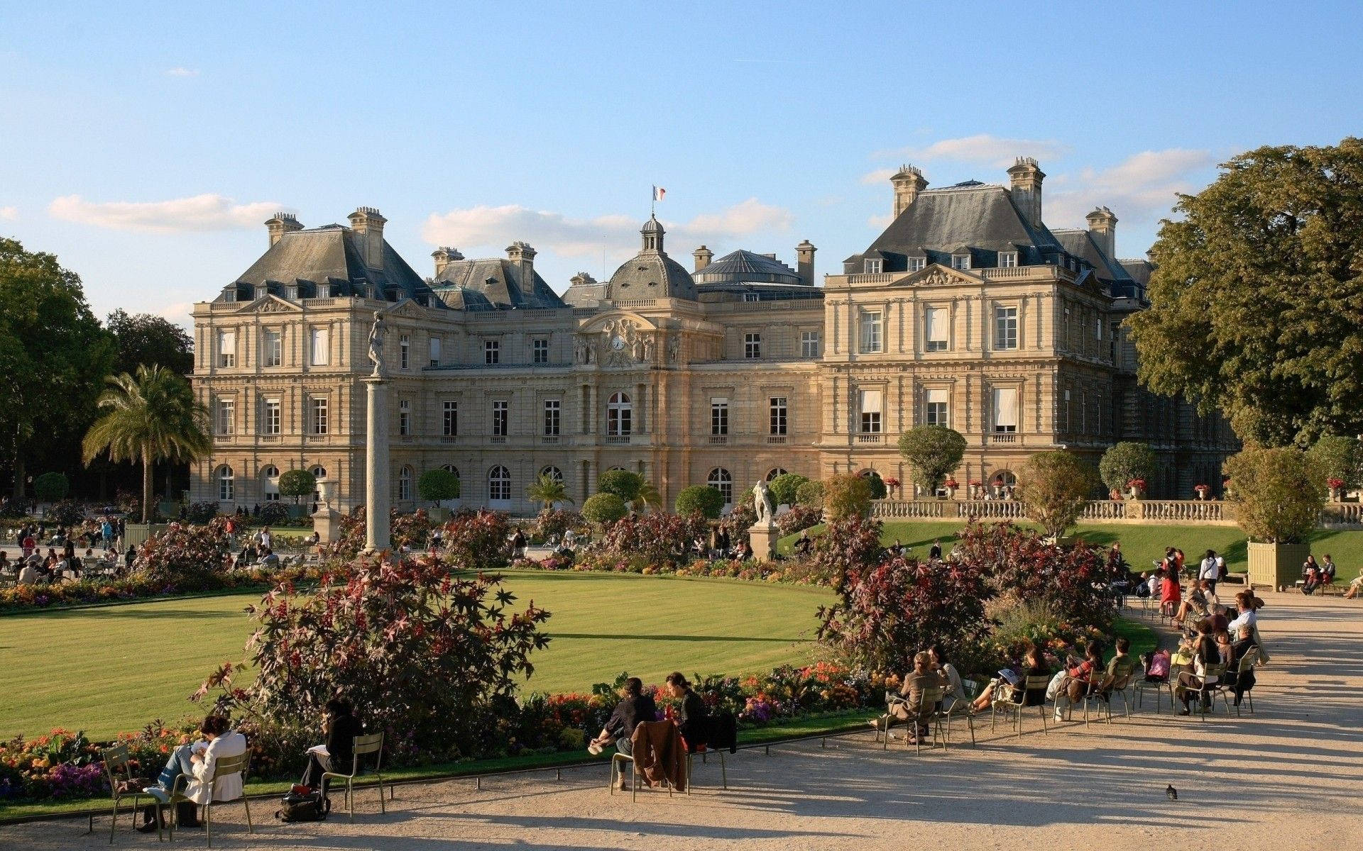 Luxembourg 桌布 壁紙 — 宏偉的新古典主義宮殿，擁有修剪整齊的花園，人們在金色午後陽光下放鬆。
