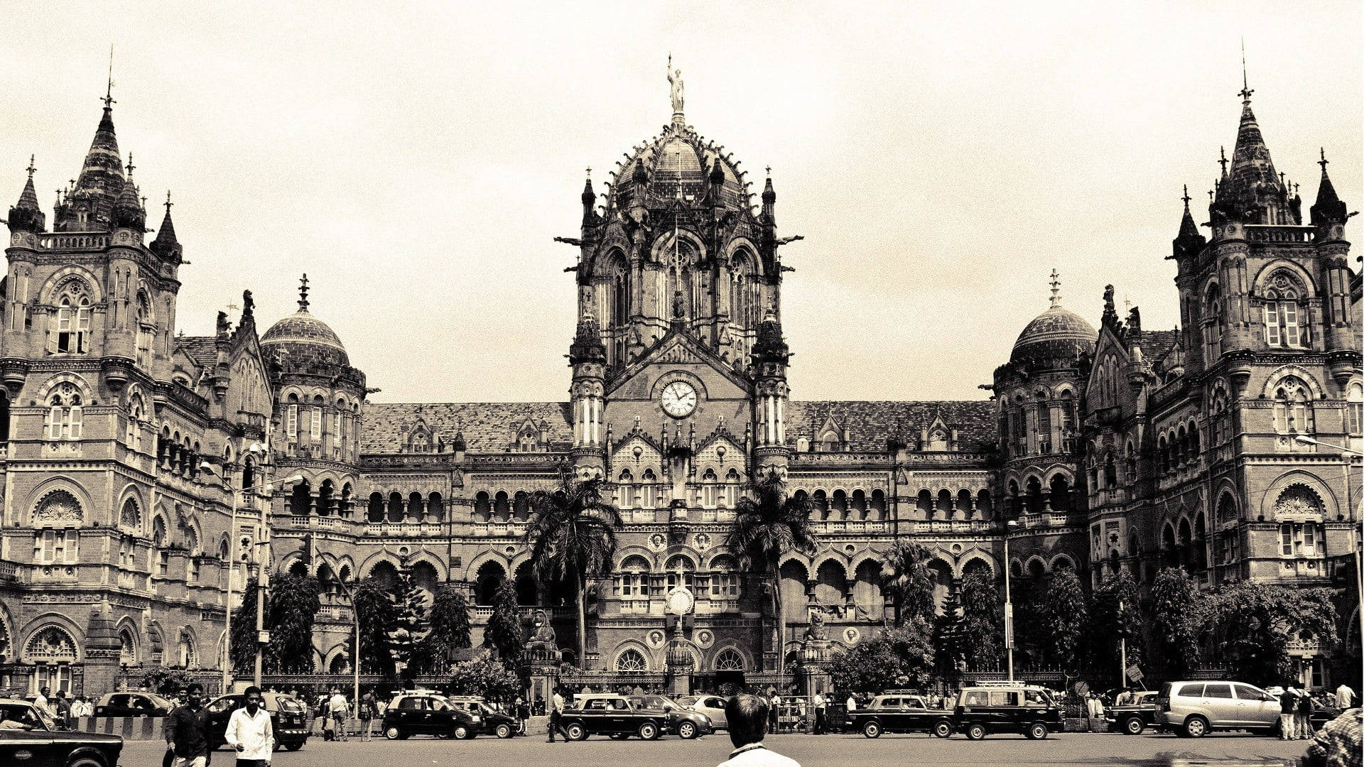 Mumbai 桌布 壁紙 — 宏偉的歷史哥德復興式建築，帶有華麗尖塔和鐘樓，威嚴地聳立在繁忙的街景之上。