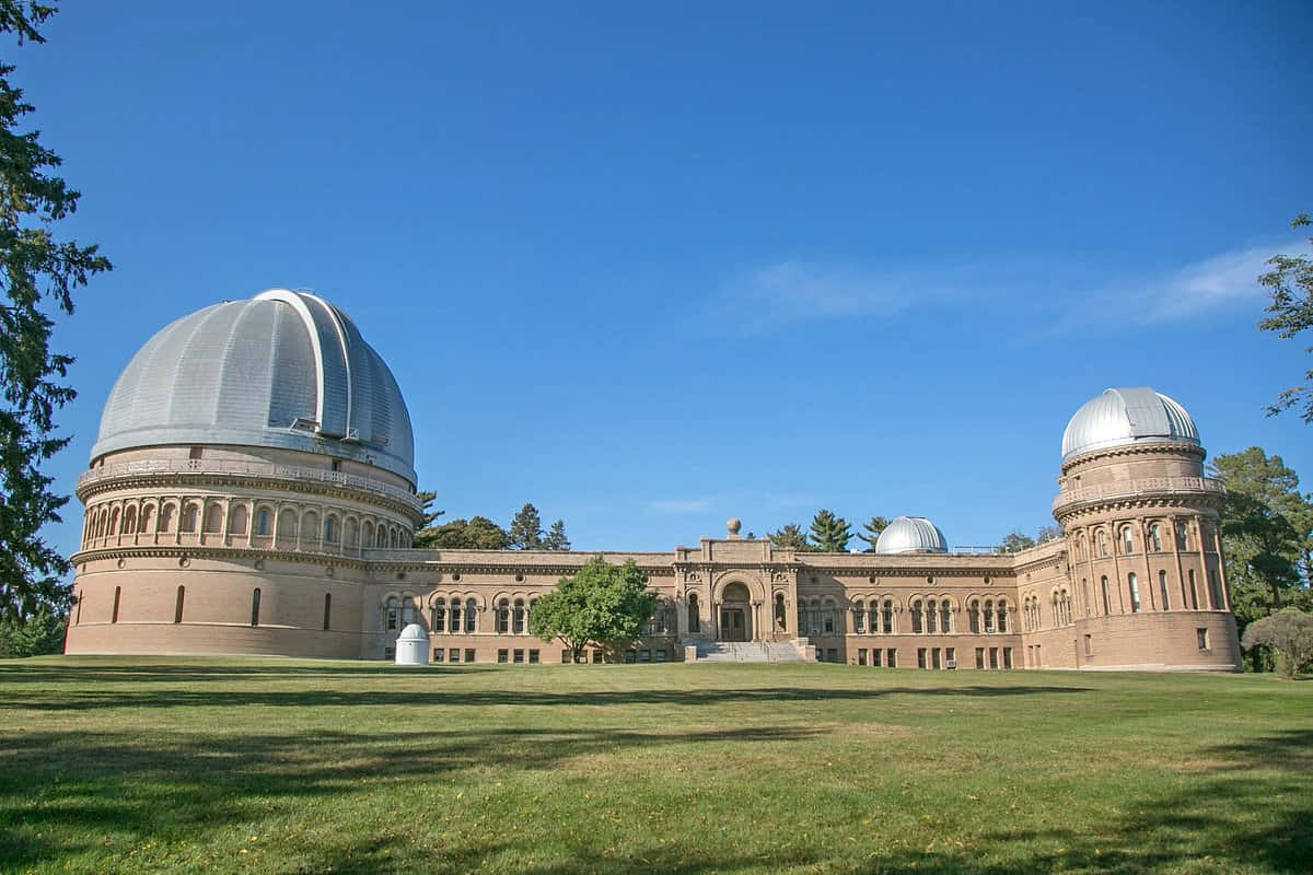 Observatory 桌布 壁紙 — 宏偉的歷史天文台，銀色圓頂在晴朗藍天下雄偉地矗立在陽光照耀的草地上。