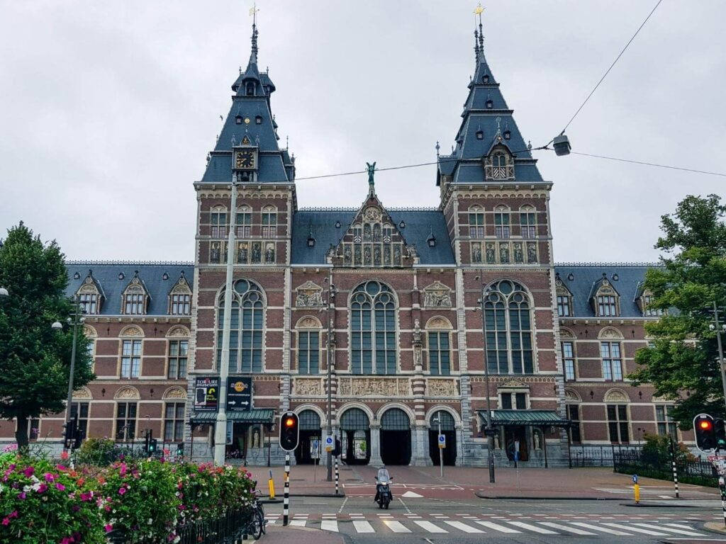 Netherlands 桌布 壁紙 — 宏偉的歷史火車站，擁有雙尖塔和華麗的磚砌外牆，天空多雲。