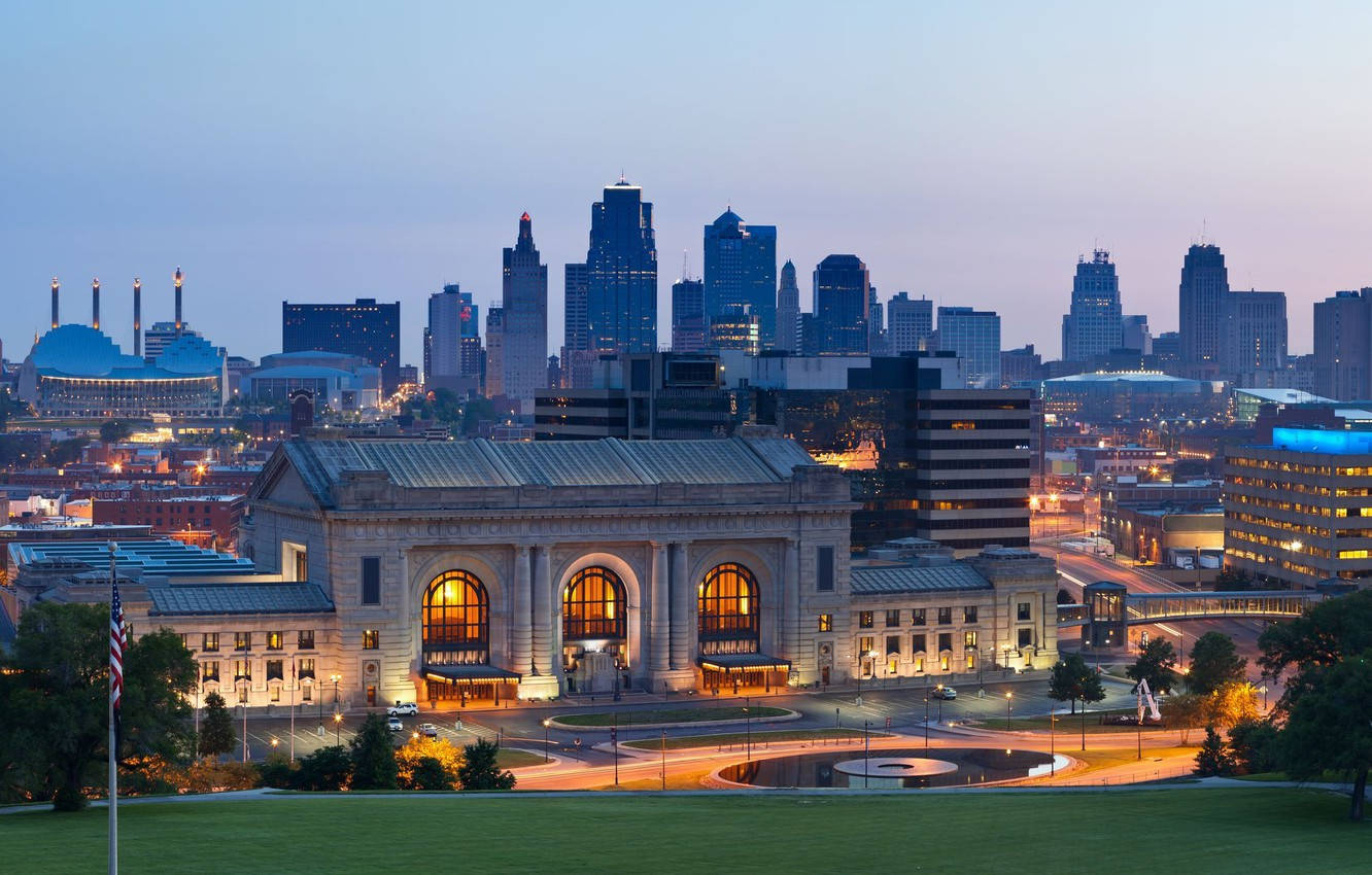 Kansas City 桌布 壁紙 — 宏偉的歷史火車站在黃昏時亮起，背後城市天際線閃耀。