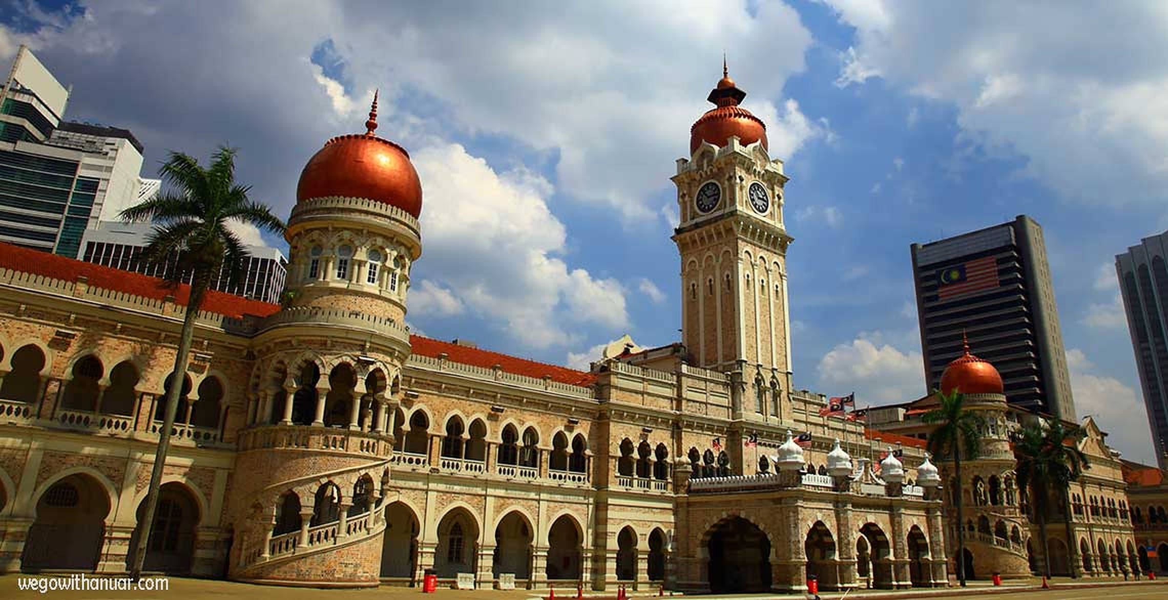 Kuala 桌布 壁紙 — 宏偉的殖民時代鐘樓，帶有銅製圓頂，在晴朗的藍天和白雲襯托下高高聳立。